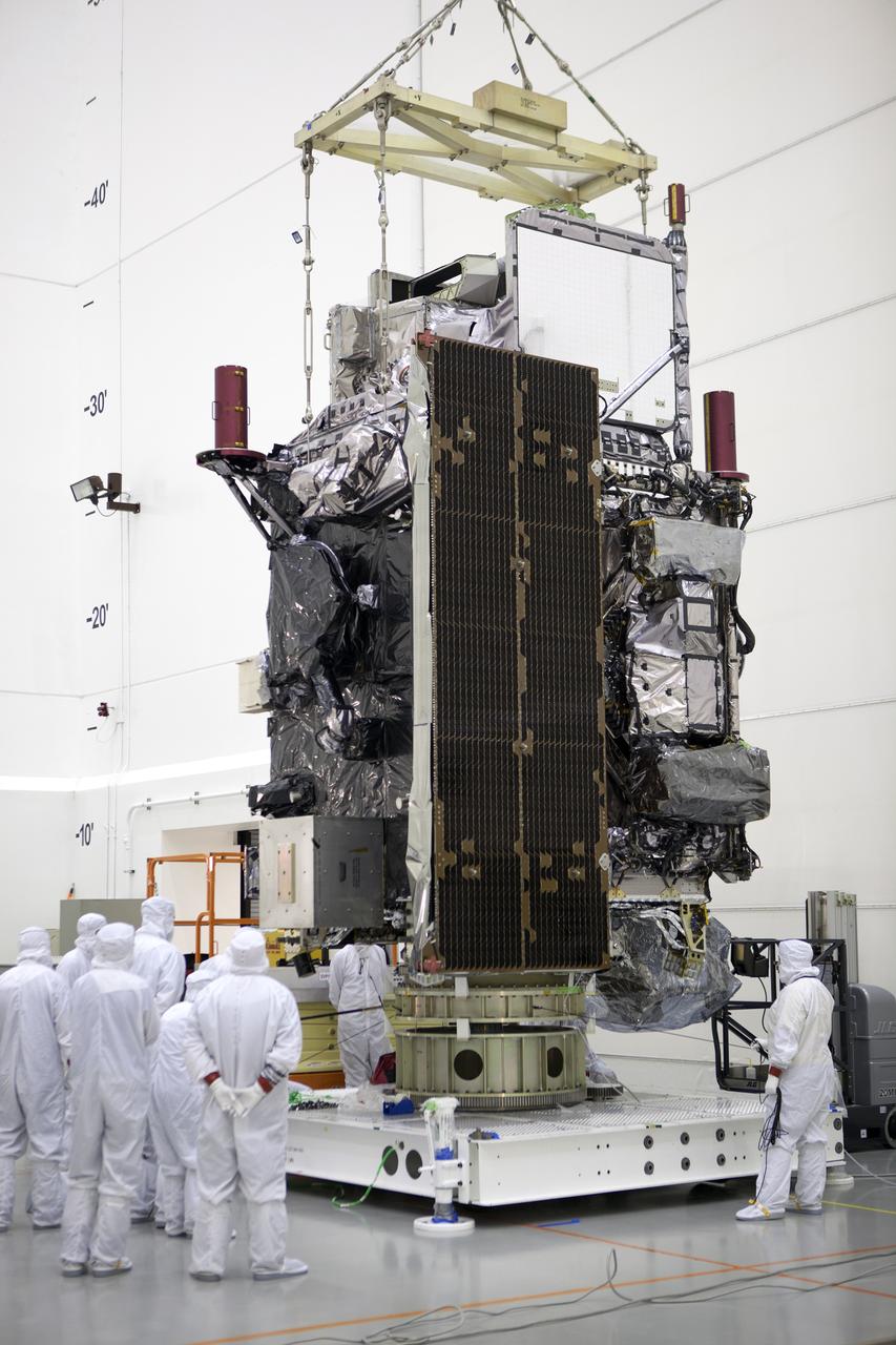 Team members monitor progress as an overhead crane lowers the GOES-R spacecraft into its work stand inside the Astrotech payload processing facility in Titusville, Florida near NASA’s Kennedy Space Center. GOES-R will be the first satellite in a series of next-generation NOAA Geostationary Operational Environmental Satellites. The spacecraft is to launch aboard a United Launch Alliance Atlas V rocket in November.
