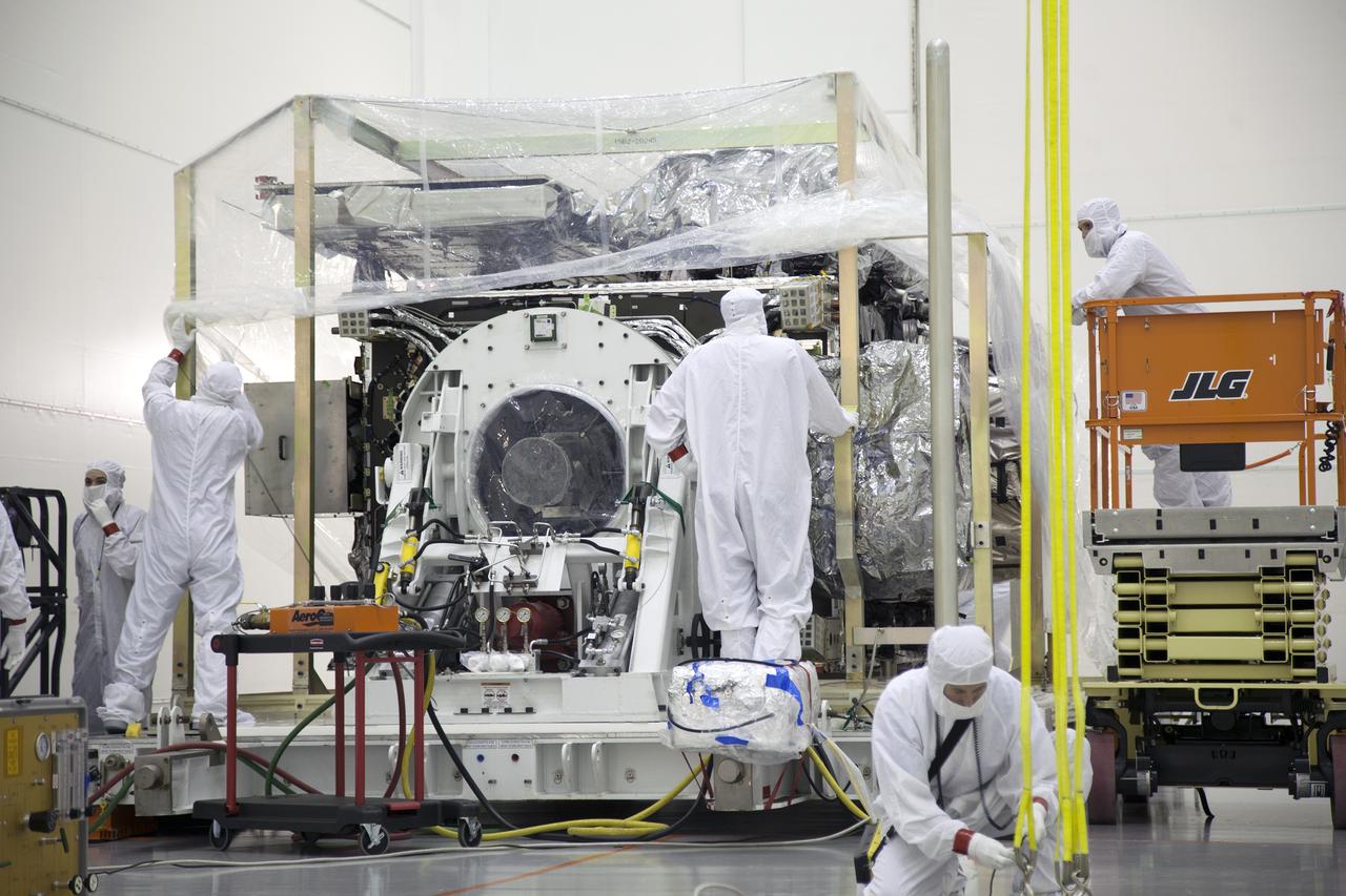 Team members remove a protective plastic covering from the GOES-R spacecraft inside the Astrotech payload processing facility in Titusville, Florida near NASA’s Kennedy Space Center. GOES-R will be the first satellite in a series of next-generation NOAA Geostationary Operational Environmental Satellites. The spacecraft is to launch aboard a United Launch Alliance Atlas V rocket in November.