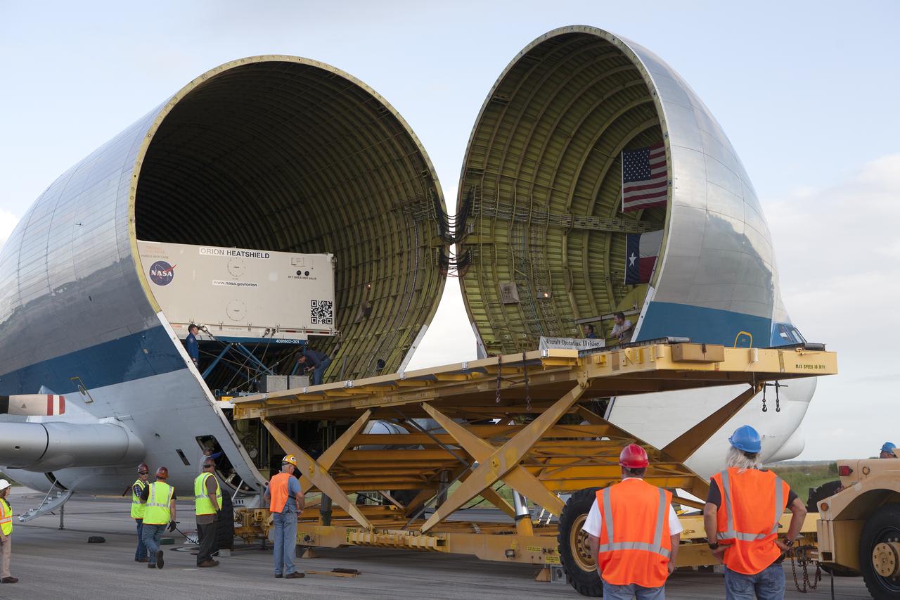Technicians with Jacobs on the Test and Operations Support Contract have positioned a platform close to NASA’s Super Guppy aircraft at the Shuttle Landing Facility, managed and operated by Space Florida, at the agency’s Kennedy Space Center in Florida, for offloading of the shipping container carrying the Orion heat shield for Exploration Mission 1 (EM-1). The heat shield will be offloaded and transported to the Neil Armstrong Operations and Checkout Building high bay for processing. The heat shield arrived from Lockheed Martin’s manufacturing facility near Denver. The Orion spacecraft will launch atop NASA’s Space Launch System rocket on EM-1, an uncrewed test flight, in 2018. 