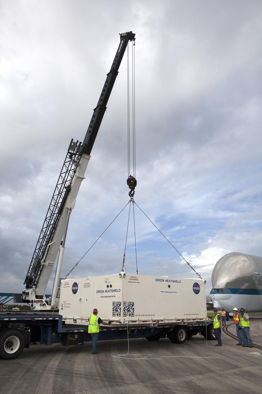 The shipping container carrying the Orion heat shield for Exploration Mission 1 (EM-1) is lowered by crane onto the flatbed of a transporter at the Shuttle Landing Facility, managed and operated by Space Florida, at NASA’s Kennedy Space Center in Florida. The heat shield arrived aboard the agency’s Super Guppy aircraft from Lockheed Martin’s manufacturing facility near Denver. The heat shield will be transported to the Neil Armstrong Operations and Checkout Building high bay for processing. The Orion spacecraft will launch atop NASA’s Space Launch System rocket on EM-1, an uncrewed test flight, in 2018. 