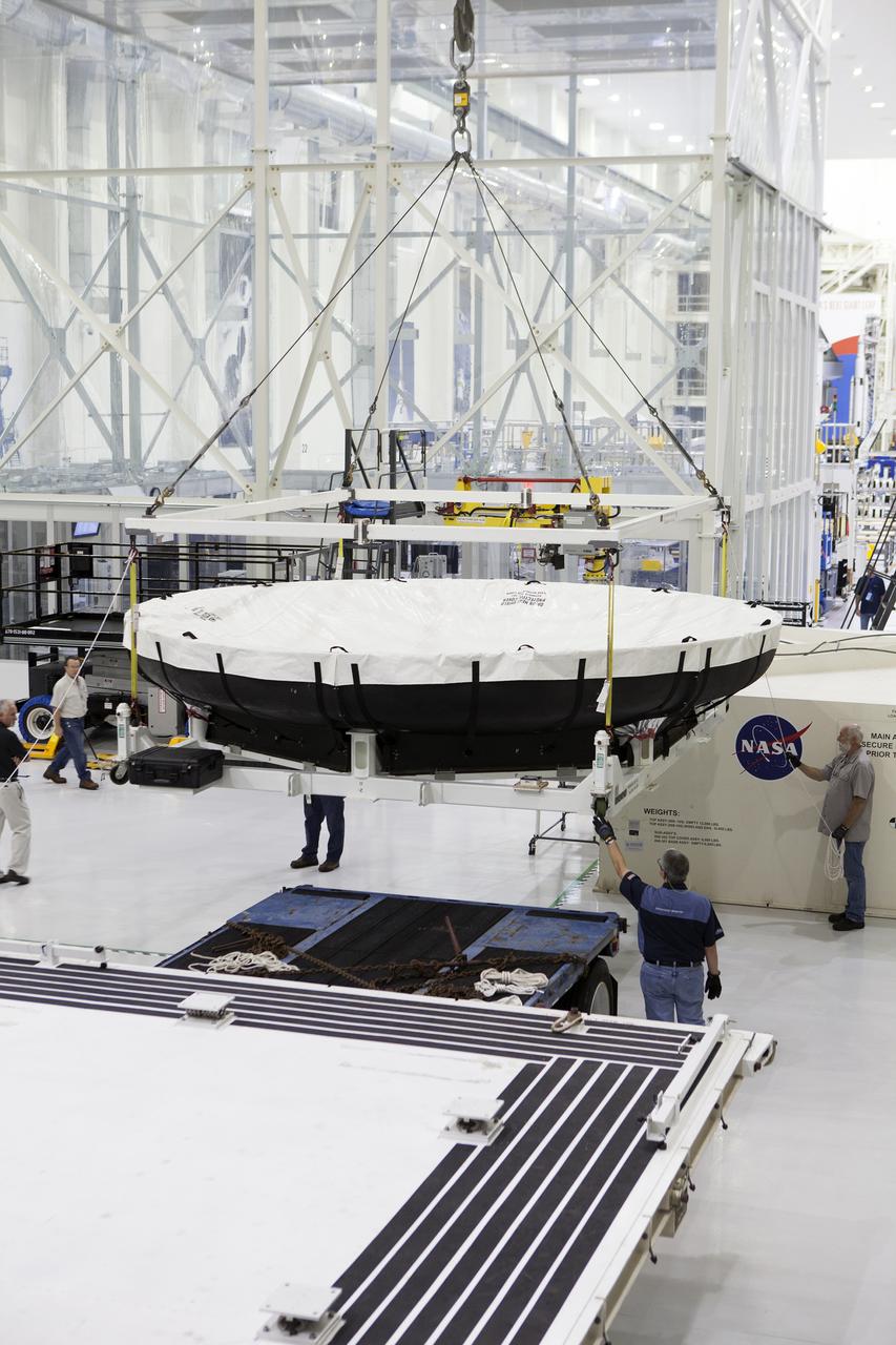 Inside the Neil Armstrong Operations and Checkout Building high bay at NASA’s Kennedy Space Center in Florida, a crane lifts the Orion heat shield for Exploration Mission 1 away from the base of its shipping container. The heat shield arrived aboard the agency’s Super Guppy aircraft at the Shuttle Landing Facility, managed and operated by Space Florida, from Lockheed Martin’s manufacturing facility near Denver. The heat shield will be moved onto a test stand to begin processing. The Orion spacecraft will launch atop NASA’s Space Launch System rocket on EM-1, an uncrewed test flight, in 2018.