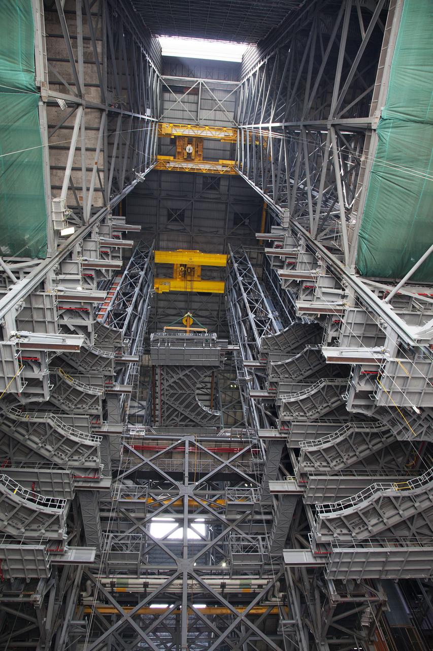 A heavy-lift crane lowers the first half of the E-level work platforms, E south, for NASA’s Space Launch System (SLS) rocket, into High Bay 3 in the Vehicle Assembly Building (VAB) at NASA’s Kennedy Space Center in Florida. The E platform will be installed on the south side of High Bay 3, about 246 feet above the floor. The E platforms are the sixth of 10 levels of work platforms that will surround and provide access to the SLS rocket and Orion spacecraft for Exploration Mission 1. The Ground Systems Development and Operations Program is overseeing upgrades and modifications to VAB High Bay 3, including installation of the new work platforms, to prepare for NASA’s journey to Mars. 