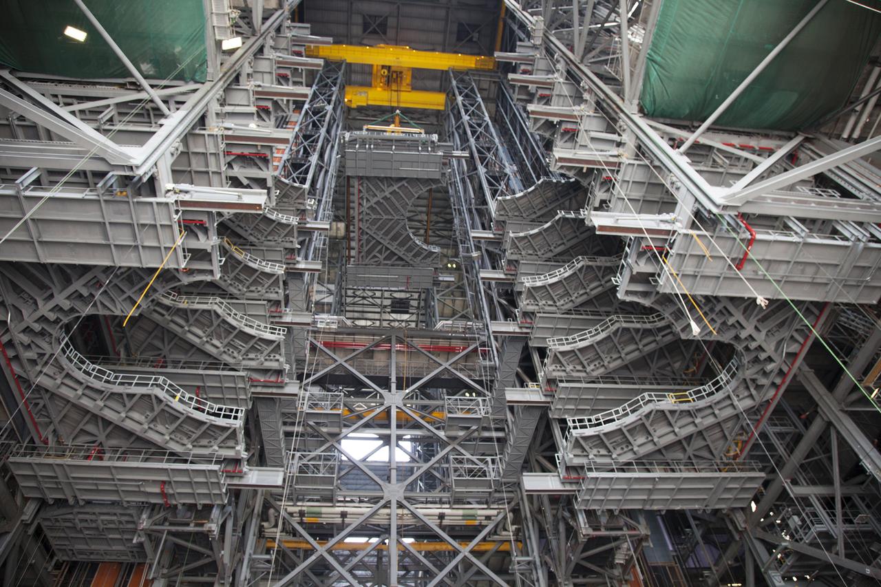 A heavy-lift crane lowers the first half of the E-level work platforms, E south, for NASA’s Space Launch System (SLS) rocket, into High Bay 3 in the Vehicle Assembly Building (VAB) at NASA’s Kennedy Space Center in Florida. In view are five levels of platforms previously installed. The E platform will be installed on the south side of High Bay 3, about 246 feet above the floor. The E platforms are the sixth of 10 levels of work platforms that will surround and provide access to the SLS rocket and Orion spacecraft for Exploration Mission 1. The Ground Systems Development and Operations Program is overseeing upgrades and modifications to VAB High Bay 3, including installation of the new work platforms, to prepare for NASA’s journey to Mars. 
