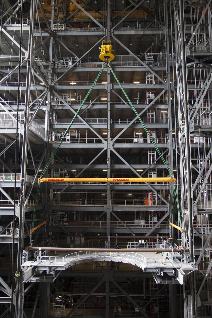 A heavy-lift crane lowers the first half of the E-level work platforms, E south, for NASA’s Space Launch System (SLS) rocket, into position for installation in High Bay 3 in the Vehicle Assembly Building (VAB) at NASA’s Kennedy Space Center in Florida. Large Tandemloc bars have been attached to the platform to keep it level during lifting and installation. The E platform will be installed on the south side of High Bay 3, about 246 feet above the floor. The E platforms are the sixth of 10 levels of work platforms that will surround and provide access to the SLS rocket and Orion spacecraft for Exploration Mission 1. The Ground Systems Development and Operations Program is overseeing upgrades and modifications to VAB High Bay 3, including installation of the new work platforms, to prepare for NASA’s journey to Mars.