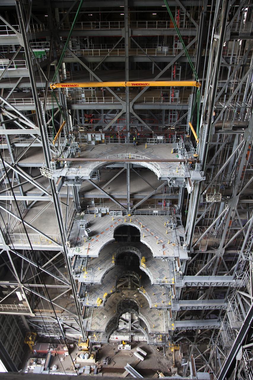 A heavy-lift crane lowers the first half of the E-level work platforms, E south, for NASA’s Space Launch System (SLS) rocket, into position for installation in High Bay 3 in the Vehicle Assembly Building (VAB) at NASA’s Kennedy Space Center in Florida. Large Tandemloc bars have been attached to the platform to keep it level during lifting and installation. In view are five levels of platforms previously installed. The E platform will be installed on the south side of High Bay 3, about 246 feet above the floor. The E platforms are the sixth of 10 levels of work platforms that will surround and provide access to the SLS rocket and Orion spacecraft for Exploration Mission 1. The Ground Systems Development and Operations Program is overseeing upgrades and modifications to VAB High Bay 3, including installation of the new work platforms, to prepare for NASA’s journey to Mars. 