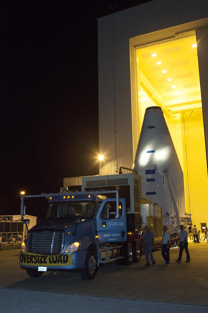 The OSIRIS-REx spacecraft, enclosed in a payload fairing, is towed from the Payload Hazardous Servicing Facility at NASA's Kennedy Space Center to begin the trip to Space Launch Complex 41 at the adjacent Cape Canaveral Air Force Station. The United Launch Alliance Atlas V rocket that is to lift OSIRIS-REx into space was stacked at SLC-41 so the spacecraft and fairing could be hoisted and bolted to the rocket promptly. The spacecraft will be sent to rendezvous with, survey and take a sample from an asteroid called Bennu.