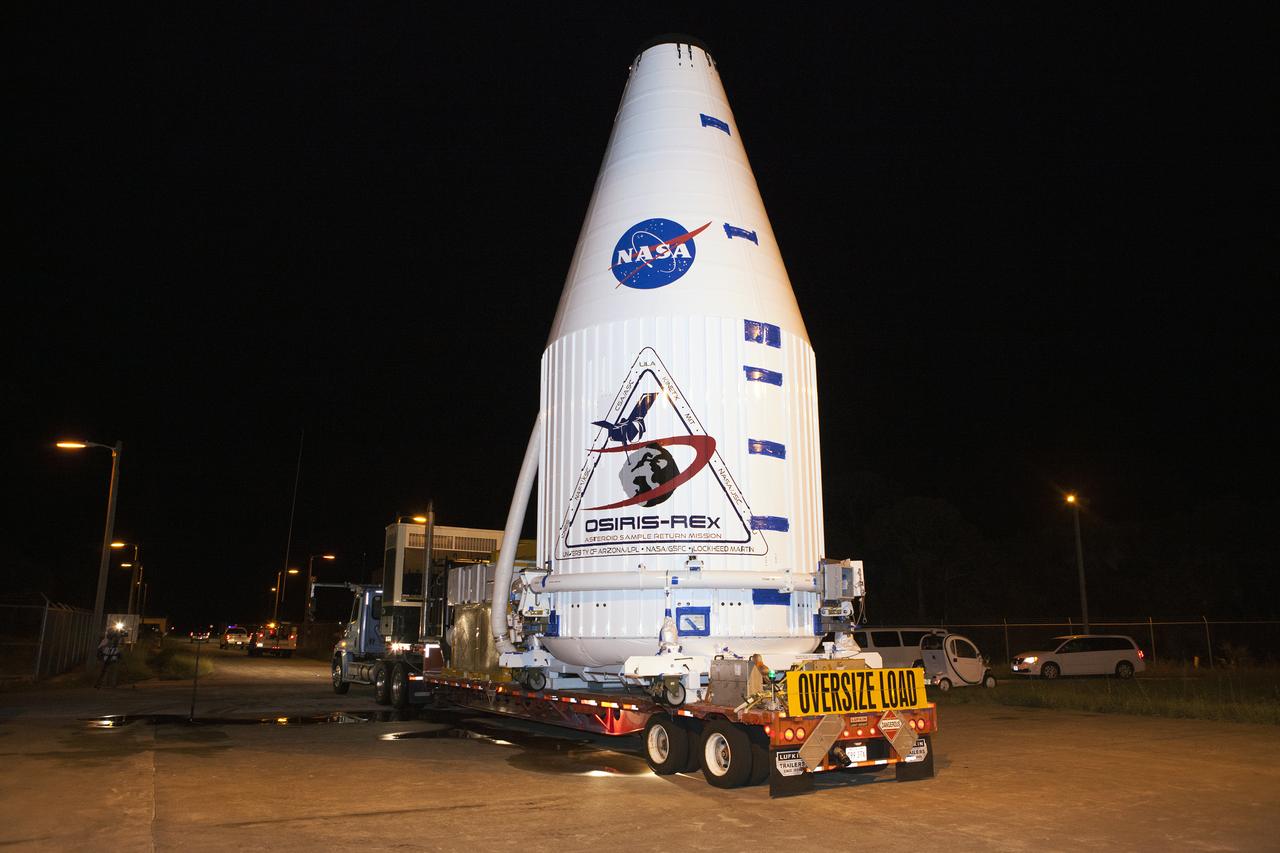 The OSIRIS-REx spacecraft, enclosed in a payload fairing, is towed from the Payload Hazardous Servicing Facility at NASA's Kennedy Space Center to begin the trip to Space Launch Complex 41 at the adjacent Cape Canaveral Air Force Station. The United Launch Alliance Atlas V rocket that is to lift OSIRIS-REx into space was stacked at SLC-41 so the spacecraft and fairing could be hoisted and bolted to the rocket promptly. The spacecraft will be sent to rendezvous with, survey and take a sample from an asteroid called Bennu. 