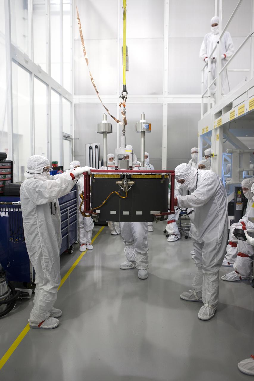Team members assist as a crane moves the Advanced Base Line Imager, the primary optical instruments, for installation on the Geostationary Operational Environmental Satellite (GOES-R) inside the Astrotech payload processing facility in Titusville, Florida near NASA’s Kennedy Space Center. GOES-R will be the first satellite in a series of next-generation NOAA GOES Satellites. The spacecraft is to launch aboard a United Launch Alliance Atlas V rocket in November. 