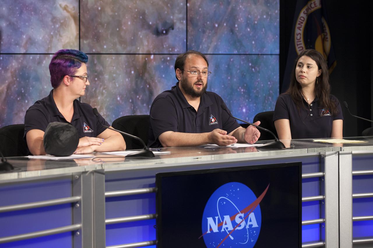 In the Kennedy Space Center’s Press Site auditorium, members of the media participate in a briefing on science experiments involved in NASA’s Origins, Spectral Interpretation, Resource Identification, Security-Regolith Explorer, or OSIRIS-REx spacecraft. From left are: Christina Richey, OSIRIS-REx deputy program scientist at NASA Headquarters in Washington; Jason Dworkin, OSIRIS-REx project scientist at NASA’s Goddard Space Flight Center in Greenbelt, Maryland; Daniella DellaGiustina, OSIRIS-REx lead image processing scientist at the University of Arizona, Tucson.