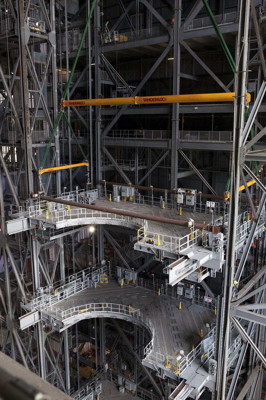 A heavy-lift crane lowers the second half of the D-level work platforms, D north, for NASA’s Space Launch System (SLS) rocket, into position for installation in High Bay 3 in the Vehicle Assembly Building at the agency’s Kennedy Space Center in Florida. The platform will be installed on the north side of the high bay. The D platforms are the seventh of 10 levels of work platforms that will surround and provide access to the SLS rocket and Orion spacecraft for Exploration Mission 1. The Ground Systems Development and Operations Program is overseeing upgrades and modifications to VAB High Bay 3, including installation of the new work platforms, to prepare for NASA’s journey to Mars.