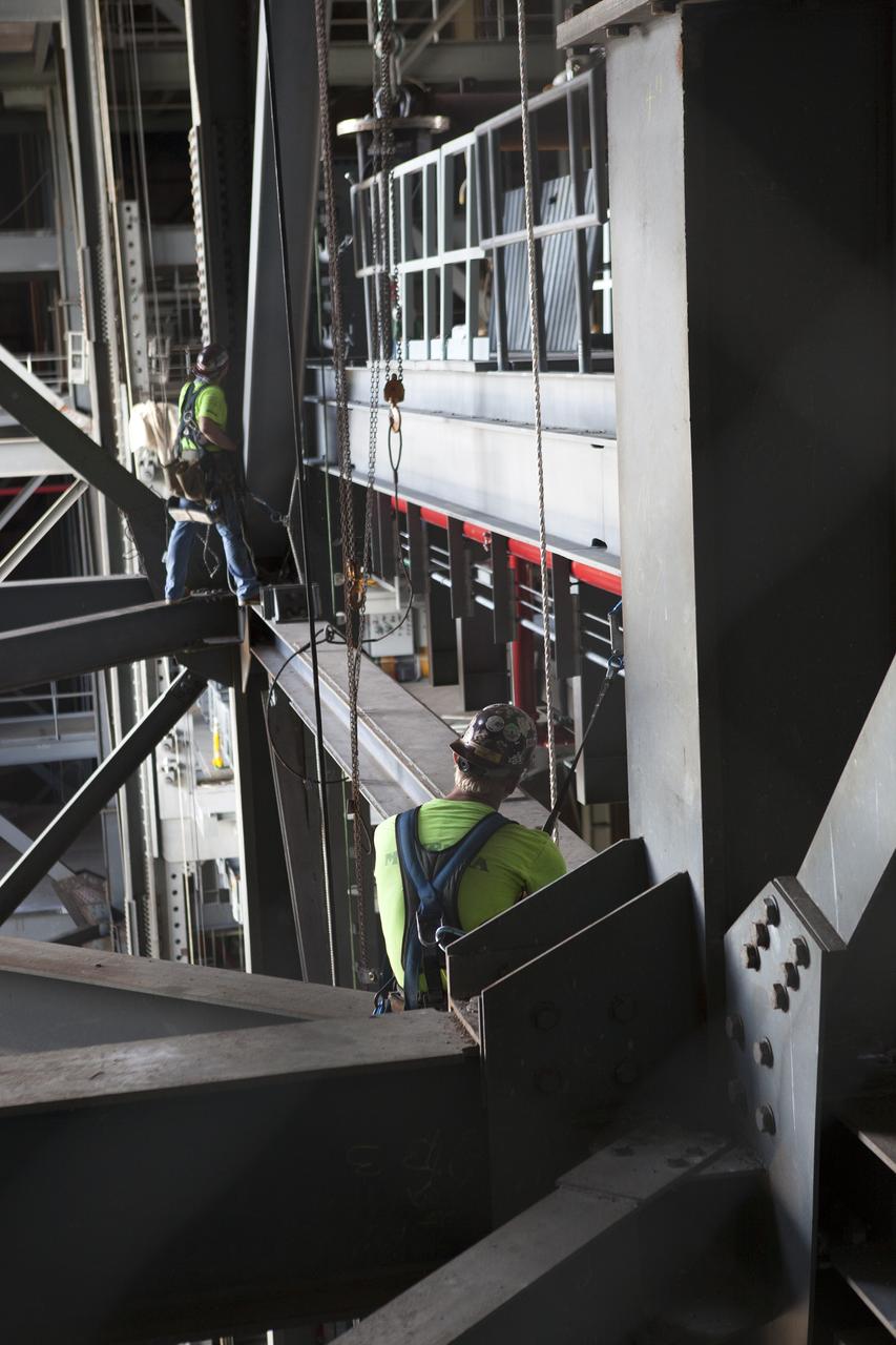 Construction workers help to secure the second half of the D-level work platforms, D north, for NASA’s Space Launch System (SLS) rocket, into position in High Bay 3 in the Vehicle Assembly Building (VAB) at the agency’s Kennedy Space Center in Florida. The D platform is being installed on the north side of the high bay. The D platforms are the seventh of 10 levels of work platforms that will surround and provide access to the SLS rocket and Orion spacecraft for Exploration Mission 1. The Ground Systems Development and Operations Program is overseeing upgrades and modifications to VAB High Bay 3, including installation of the new work platforms, to prepare for NASA’s journey to Mars.