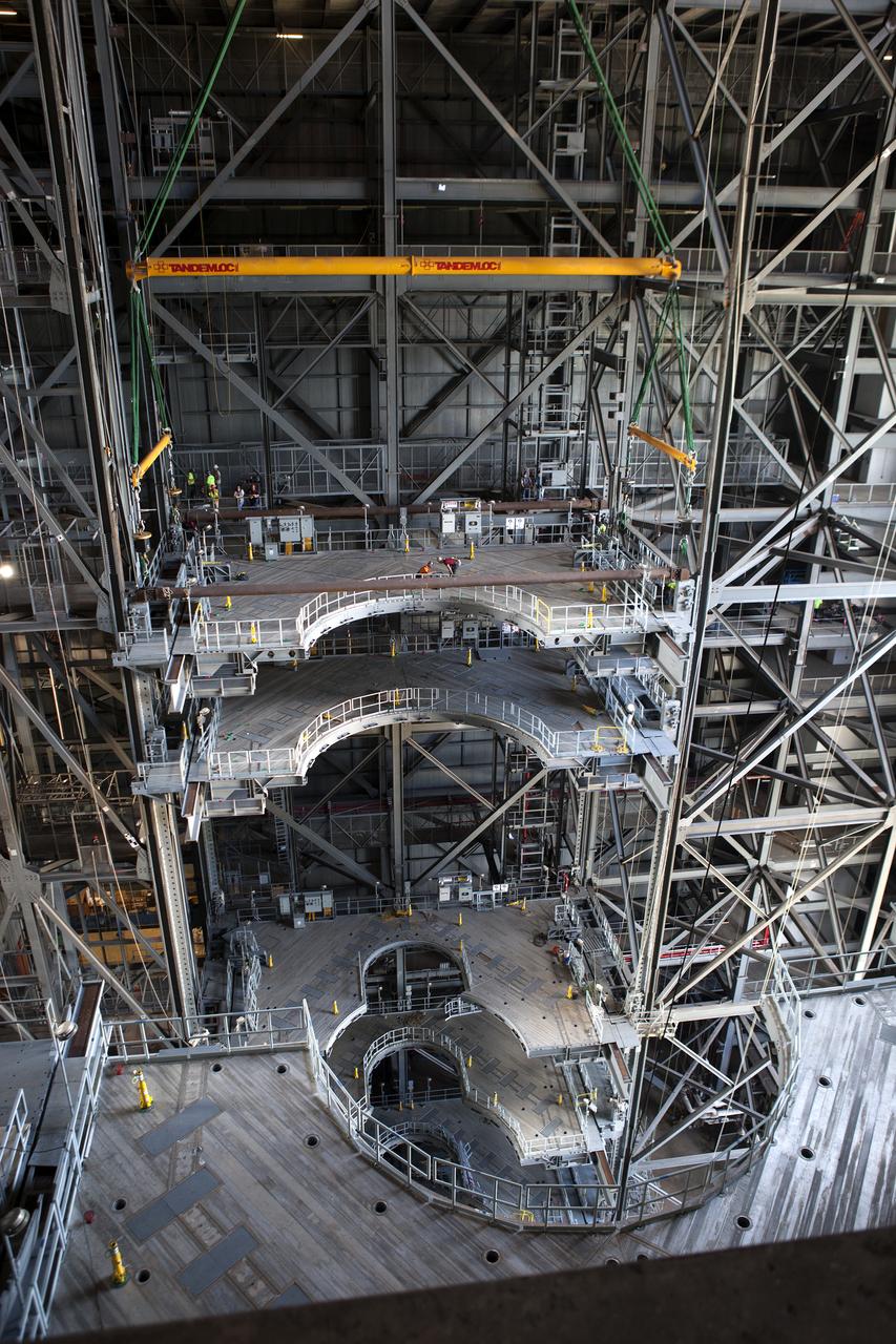 A heavy-lift crane lowers the second half of the D-level work platforms, D north, for NASA’s Space Launch System (SLS) rocket, into position for installation in High Bay 3 in the Vehicle Assembly Building (VAB) at the agency’s Kennedy Space Center in Florida. The platform will be installed on the north side of the high bay. The D platforms are the seventh of 10 levels of work platforms that will surround and provide access to the SLS rocket and Orion spacecraft for Exploration Mission 1. The Ground Systems Development and Operations Program is overseeing upgrades and modifications to VAB High Bay 3, including installation of the new work platforms, to prepare for NASA’s journey to Mars. 