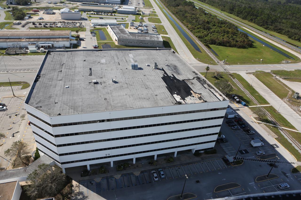 The roof of the Operations Support Building I is seen during an aerial survey of NASA's Kennedy Space Center in Florida on Saturday. The survey was performed to identify structures and facilities that may have sustained damage from Hurricane Matthew as the storm passed to the east of Kennedy on Oct. 6 and 7, 2016. Officials determined that the center received some isolated roof damage, damaged support buildings, a few downed power lines, and limited water intrusion. Beach erosion also occurred, although the storm surge was less than expected. NASA closed the center ahead of the storm’s onset and only a small team of specialists known as the Rideout Team was on the center as the storm approached and passed.