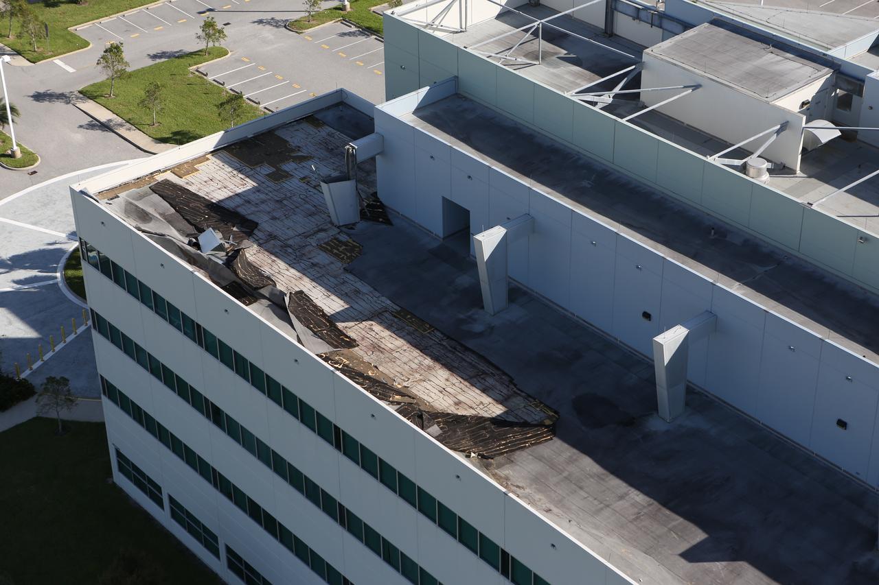 The roof of the Operations Support Building II is seen during an aerial survey of NASA's Kennedy Space Center in Florida on Saturday. The survey was performed to identify structures and facilities that may have sustained damage from Hurricane Matthew as the storm passed to the east of Kennedy on Oct. 6 and 7, 2016. Officials determined that the center received some isolated roof damage, damaged support buildings, a few downed power lines, and limited water intrusion. Beach erosion also occurred, although the storm surge was less than expected. NASA closed the center ahead of the storm’s onset and only a small team of specialists known as the Rideout Team was on the center as the storm approached and passed.