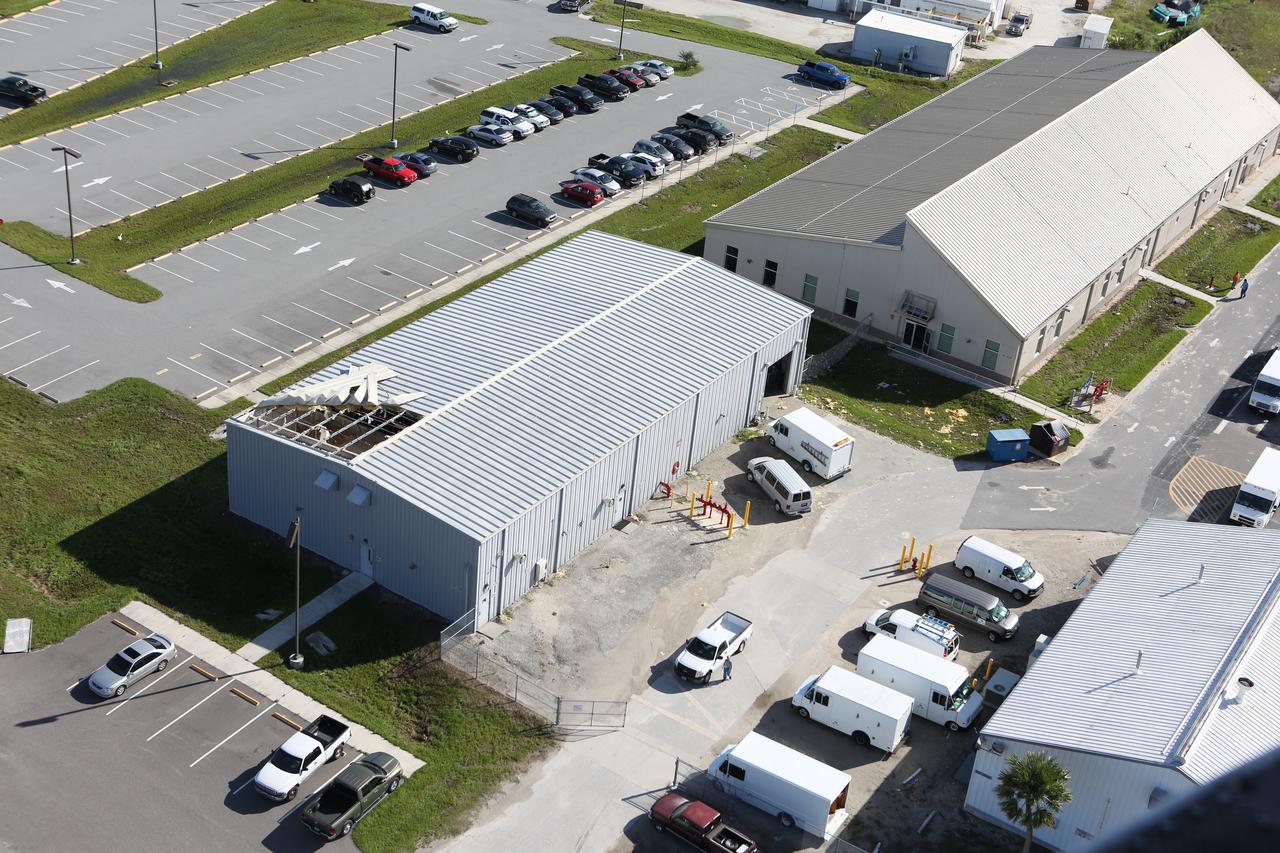 Damage to a facility roof is seen during an aerial survey of NASA's Kennedy Space Center in Florida on Saturday. The survey was performed to identify structures and facilities that may have sustained damage from Hurricane Matthew as the storm passed to the east of Kennedy on Oct. 6 and 7, 2016. Officials determined that the center received some isolated roof damage, damaged support buildings, a few downed power lines, and limited water intrusion. Beach erosion also occurred, although the storm surge was less than expected. NASA closed the center ahead of the storm’s onset and only a small team of specialists known as the Rideout Team was on the center as the storm approached and passed