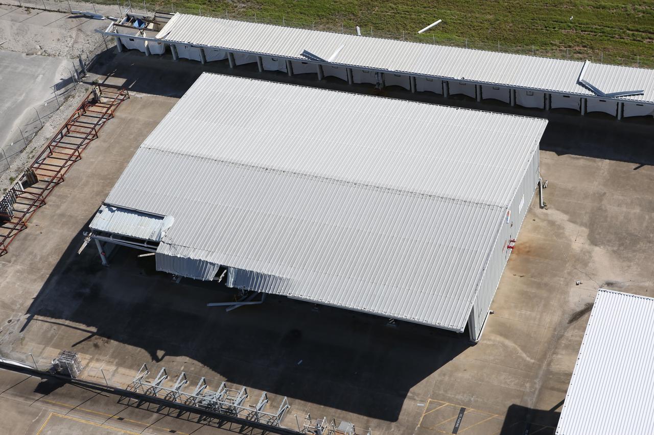 Damage to a facility roof is seen during an aerial survey of NASA's Kennedy Space Center in Florida on Saturday. The survey was performed to identify structures and facilities that may have sustained damage from Hurricane Matthew as the storm passed to the east of Kennedy on Oct. 6 and 7, 2016. Officials determined that the center received some isolated roof damage, damaged support buildings, a few downed power lines, and limited water intrusion. Beach erosion also occurred, although the storm surge was less than expected. NASA closed the center ahead of the storm’s onset and only a small team of specialists known as the Rideout Team was on the center as the storm approached and passed.