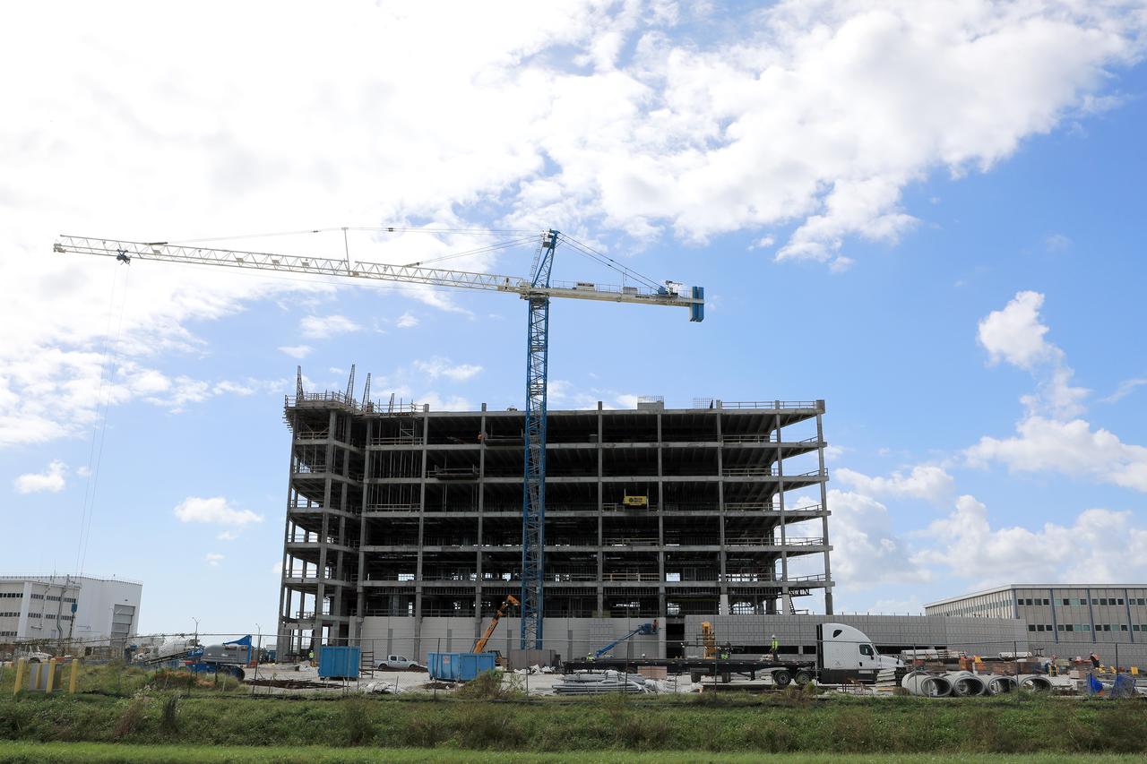 A large crane towers overhead as the new, seven-story headquarters building takes shape in the industrial area at NASA’s Kennedy Space Center in Florida. The 200,000-square-foot facility will anchor the spaceport’s Central Campus and house about 500 NASA civil service and contractor employees. The building will be more energy efficient than the current Headquarters building and will feature the latest in office and administrative building technology to fulfill Kennedy's role as the premiere multi-user spaceport for NASA and, increasingly, commercial entities.