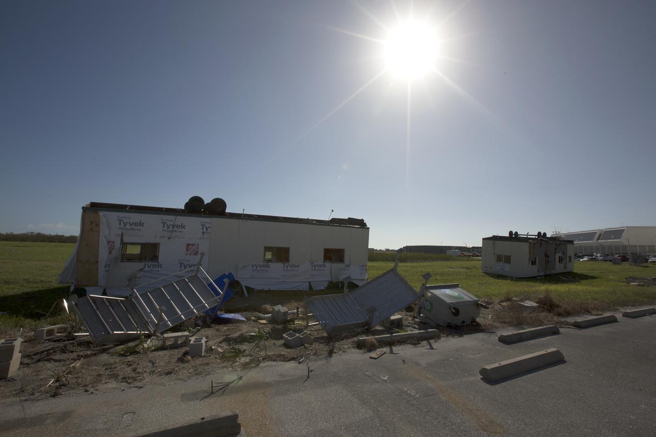 Damaged construction trailers and several pieces of associated debris, aftermath of Hurricane Matthew, are seen in front of the Mobile Launcher in the Launch Complex 39 area at NASA's Kennedy Space Center in Florida.  Assessments and repairs are in progress at various structures and facilities across the spaceport, part of the ongoing recovery from Hurricane Matthew, which passed to the east of Kennedy on Oct. 6 and 7, 2016. The center received some isolated roof damage, damaged support buildings, a few downed power lines, and limited water intrusion. Beach erosion also occurred, although the storm surge was less than expected.