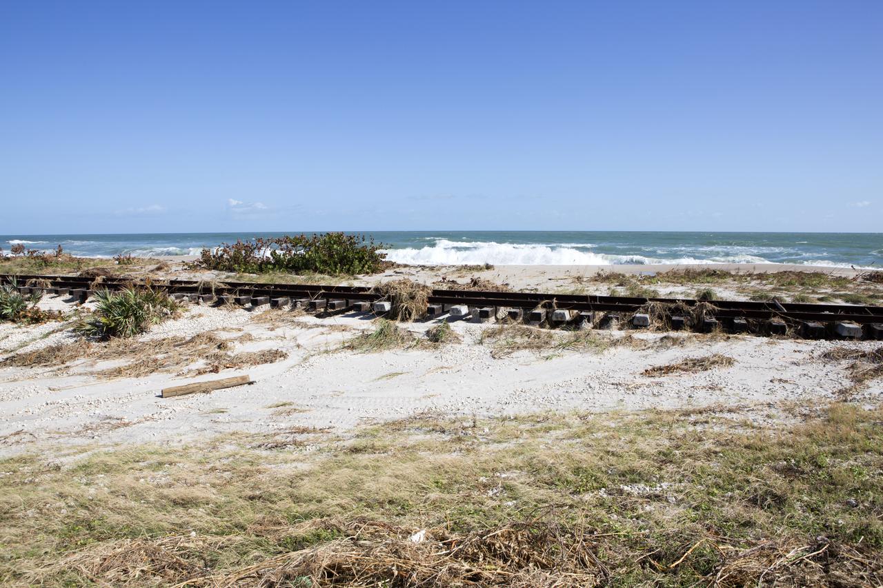 Plant debris left behind by Hurricane Matthew covers a stretch of the NASA Railroad near Launch Pads 39A and B at Kennedy Space Center in Florida.  A portion of the line near the ocean was used during the Apollo era, although some portions were used to deliver commodities to the nearby Cape Canaveral Air Force Station through the end of the Titan program. NASA determined it was financially and ecologically advantageous to leave the tracks in place. Hurricane Matthew, a Category 3 storm, passed to the east of Kennedy on Oct. 6 and 7, 2016. The center received some isolated roof damage, damaged support buildings, a few downed power lines, and limited water intrusion. Beach erosion also occurred, although the storm surge was less than expected.