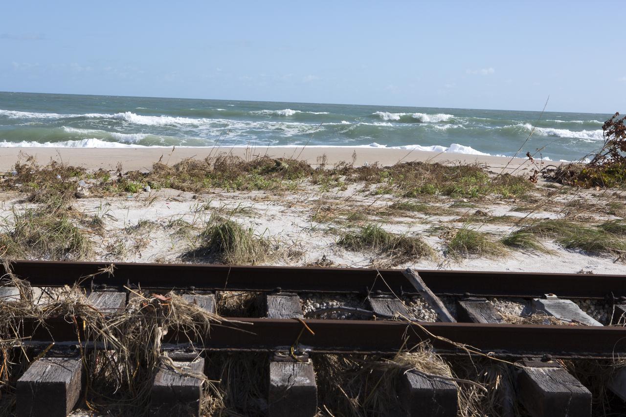 Plant debris left behind by Hurricane Matthew covers a stretch of the NASA Railroad near Launch Pads 39A and B at Kennedy Space Center in Florida.  A portion of the line near the ocean was used during the Apollo era, although some portions were used to deliver commodities to the nearby Cape Canaveral Air Force Station through the end of the Titan program. NASA determined it was financially and ecologically advantageous to leave the tracks in place. Hurricane Matthew, a Category 3 storm, passed to the east of Kennedy on Oct. 6 and 7, 2016. The center received some isolated roof damage, damaged support buildings, a few downed power lines, and limited water intrusion. Beach erosion also occurred, although the storm surge was less than expected.