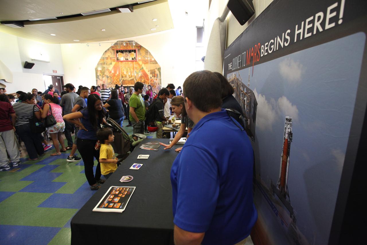 Students visit the displays at the Logan Heights Library in San Diego, California, during the “52 Weeks of Science” celebration. The Ground Systems Development and Operations (GSDO) Program is participating in the special event with a Journey to Mars display before the start of Underway Recovery Test 5 using a test version of the Orion spacecraft in the Pacific Ocean off the coast of California. The test will allow NASA, Orion manufacturer Lockheed Martin and the U.S. Navy to demonstrate and evaluate the recovery processes, procedures, hardware and personnel necessary for recovery of the Orion crew module on its return from a deep space mission. Orion is the exploration spacecraft designed to carry astronauts to destinations not yet explored by humans, including an asteroid and NASA Journey to Mars. It will have emergency abort capability, sustain the crew during space travel and provide safe re-entry from deep space return velocities. Orion is scheduled to launch atop NASA’s Space Launch System rocket in 2018. For more information, visit http://www.nasa.gov/orion. 