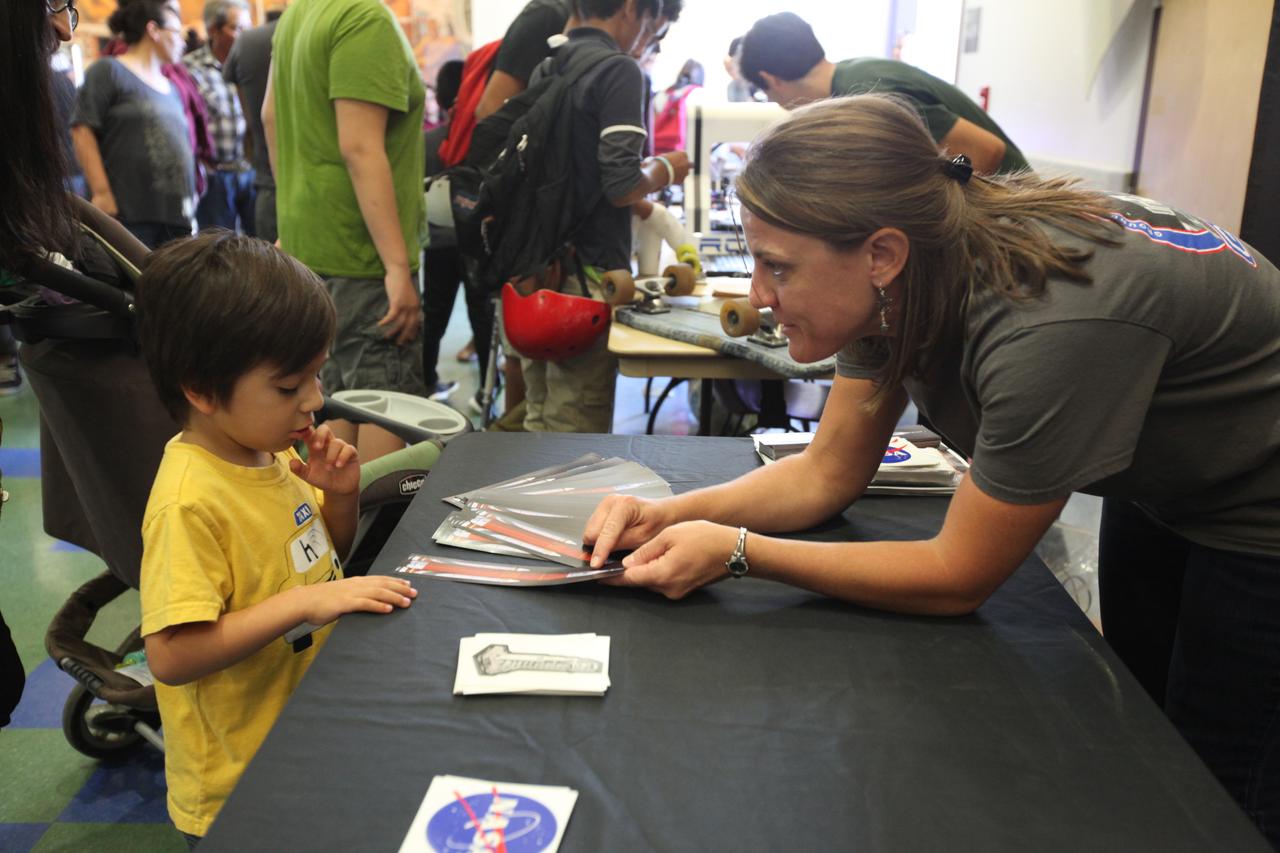 A young student visits the displays at the Logan Heights Library in San Diego, California, during the “52 Weeks of Science” celebration. The Ground Systems Development and Operations (GSDO) Program is participating in the special event with a Journey to Mars display before the start of Underway Recovery Test 5 using a test version of the Orion spacecraft in the Pacific Ocean off the coast of California. The test will allow NASA, Orion manufacturer Lockheed Martin and the U.S. Navy to demonstrate and evaluate the recovery processes, procedures, hardware and personnel necessary for recovery of the Orion crew module on its return from a deep space mission. Orion is the exploration spacecraft designed to carry astronauts to destinations not yet explored by humans, including an asteroid and NASA Journey to Mars. It will have emergency abort capability, sustain the crew during space travel and provide safe re-entry from deep space return velocities. Orion is scheduled to launch atop NASA’s Space Launch System rocket in 2018. For more information, visit http://www.nasa.gov/orion. 