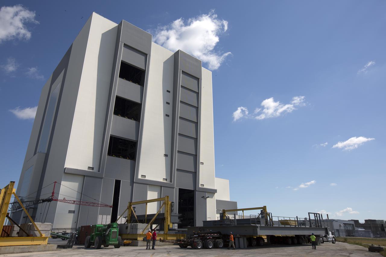 A heavy load transport truck from Tillett Heavy Hauling in Titusville, Florida, arrives at the Vehicle Assembly Building (VAB) at NASA’s Kennedy Space Center in Florida, carrying the first half of the B-level work platforms, B South, for the agency’s Space Launch System (SLS) rocket. The platform will be offloaded in the VAB staging area in the west parking lot. The Ground Systems Development and Operations Program is overseeing upgrades and modifications to VAB High Bay 3 to support processing of the SLS and Orion spacecraft. A total of 10 levels of new platforms, 20 platform halves altogether, will surround the SLS rocket and Orion spacecraft and provide access for testing and processing.