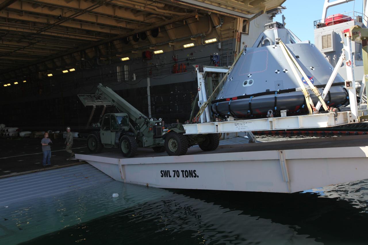 The test version of the Orion crew module is transported into the well deck of the USS San Diego at Naval Base San Diego in California. NASA, Orion manufacturer Lockheed Martin and the U.S. Navy will head out to sea with the Orion test spacecraft aboard for Underway Recovery Test 5 (URT-5) in the Pacific Ocean off the coast of California. During URT-5, the team will demonstrate and evaluate the recovery processes, procedures, hardware and personnel necessary for recovery of Orion on its return from a deep space mission. Orion is the exploration spacecraft designed to carry astronauts to destinations not yet explored by humans, including an asteroid and NASA Journey to Mars. It will have emergency abort capability, sustain the crew during space travel and provide safe re-entry from deep space return velocities. Orion is scheduled to launch atop NASA’s Space Launch System rocket in 2018. For more information, visit http://www.nasa.gov/orion. 