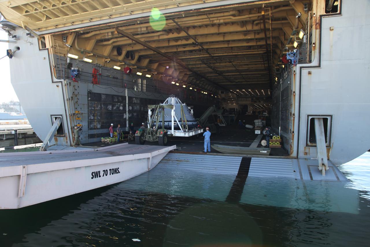 Team members monitor the progress as the test version of the Orion crew module is transported into the well deck of the USS San Diego at Naval Base San Diego in California. NASA, Orion manufacturer Lockheed Martin and the U.S. Navy will head out to sea with the Orion test spacecraft aboard for Underway Recovery Test 5 (URT-5) in the Pacific Ocean off the coast of California. During URT-5, the team will demonstrate and evaluate the recovery processes, procedures, hardware and personnel necessary for recovery of Orion on its return from a deep space mission. Orion is the exploration spacecraft designed to carry astronauts to destinations not yet explored by humans, including an asteroid and NASA Journey to Mars. It will have emergency abort capability, sustain the crew during space travel and provide safe re-entry from deep space return velocities. Orion is scheduled to launch atop NASA’s Space Launch System rocket in 2018. For more information, visit http://www.nasa.gov/orion.