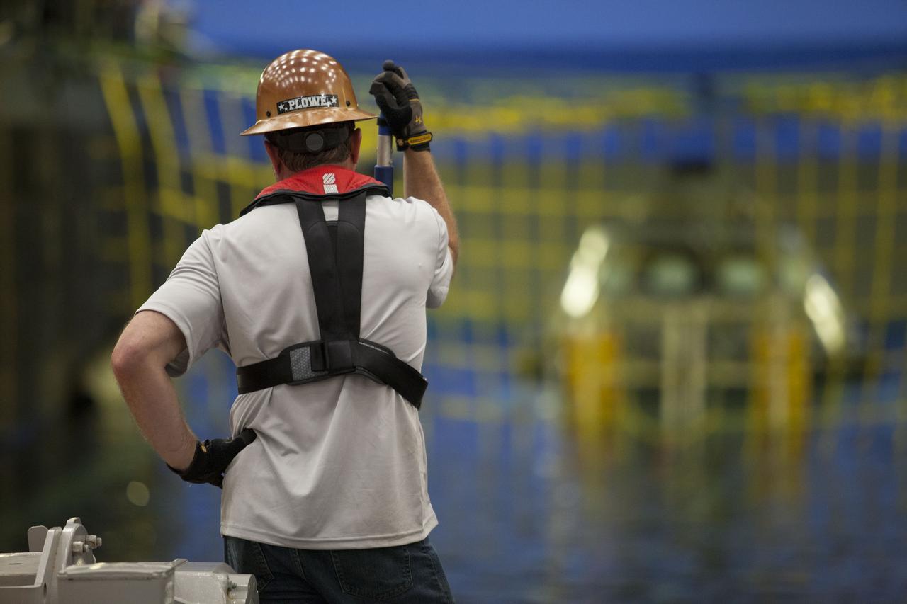 A member of the recovery team watches as a test version of the Orion crew module is secured in the flooded well deck of the USS San Diego for the start of Underway Recovery Test 5 in the Pacific Ocean off the coast of California. NASA's Ground Systems Development and Operations Program and the U.S. Navy are conducting a series of tests to prepare for recovery of Orion on its return from deep space missions. The testing will allow the team to demonstrate and evaluate recovery processes, procedures, hardware and personnel in open waters. Orion is the exploration spacecraft designed to carry astronauts to destinations not yet explored by humans, including an asteroid and NASA's Journey to Mars. It will have emergency abort capability, sustain the crew during space travel and provide safe re-entry from deep space return velocities. Orion is scheduled to launch on NASA's Space Launch System in late 2018. For more information, visit http://www.nasa.gov/orion. 