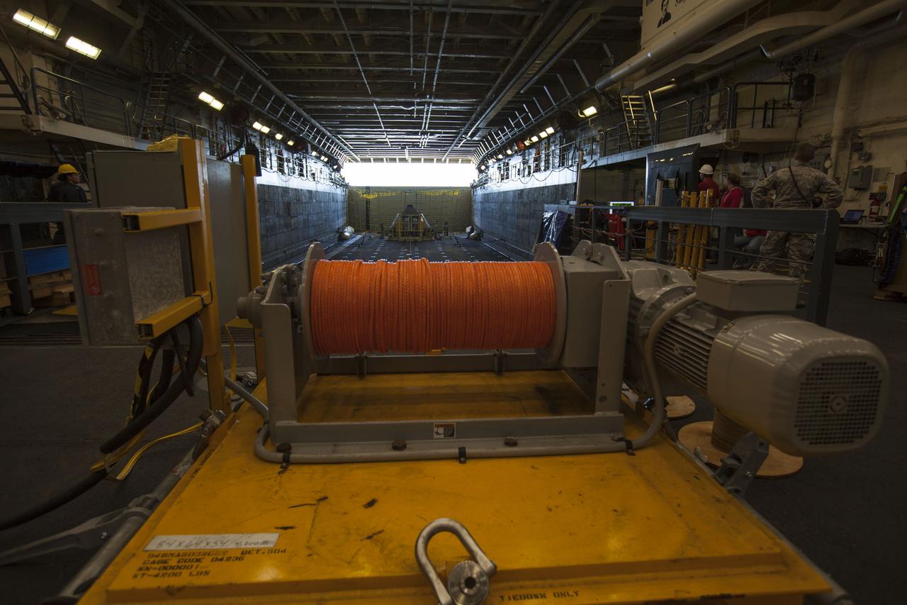A test version of the Orion crew module is secured in the well deck of the USS San Diego for Underway Recovery Test 5 in the Pacific Ocean off the coast of California. In view is the winch system that will be used to help retrieve the crew module during a series of tests in open waters. NASA's Ground Systems Development and Operations Program and the U.S. Navy will practice retrieving and securing the crew module in the well deck of the ship using a set of tethers and the winch system to prepare for recovery of Orion on its return from deep space missions. The testing will allow the team to demonstrate and evaluate recovery processes, procedures, hardware and personnel in open waters. Orion is the exploration spacecraft designed to carry astronauts to destinations not yet explored by humans, including an asteroid and NASA's Journey to Mars. It will have emergency abort capability, sustain the crew during space travel and provide safe re-entry from deep space return velocities. Orion is scheduled to launch on NASA's Space Launch System in late 2018. For more information, visit http://www.nasa.gov/orion. 
