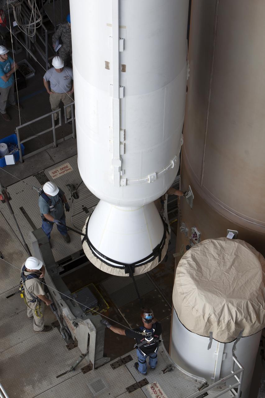 Technicians with United Launch Alliance (ULA) monitor the progress as the solid rocket motor is mated to the ULA Atlas V rocket in the Vertical Integration Facility at Space Launch Complex 41 at Cape Canaveral Air Force Station in Florida. NOAA's Geostationary Operational Environmental Satellite (GOES-R) will launch aboard the Atlas V rocket this month. GOES-R is the first satellite in a series of next-generation NOAA GOES Satellites.