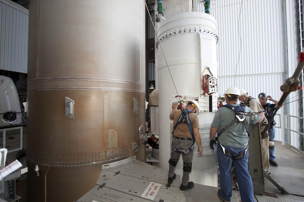Technicians with United Launch Alliance (ULA) assist as the solid rocket motor is mated to the ULA Atlas V rocket in the Vertical Integration Facility at Space Launch Complex 41 at Cape Canaveral Air Force Station in Florida. NOAA's Geostationary Operational Environmental Satellite (GOES-R) will launch aboard the Atlas V rocket this month. GOES-R is the first satellite in a series of next-generation NOAA GOES Satellites.