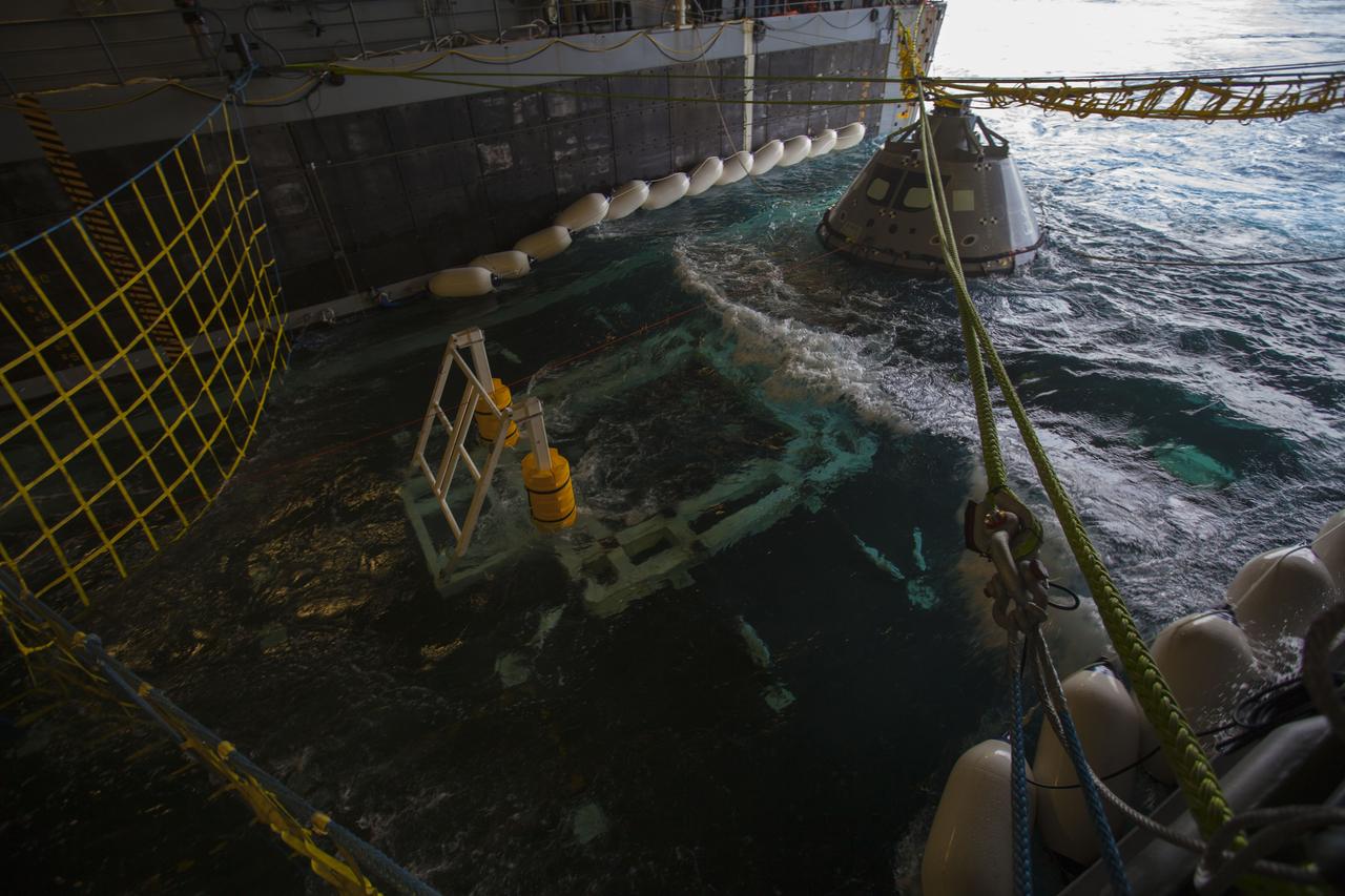A test version of the Orion crew module is guided into the flooded well deck of the USS San Diego for Underway Recovery Test 5. NASA's Ground Systems Development and Operations Program and the U.S. Navy will conduct a series of tests using the ship's well deck, the test module, various watercraft and equipment to prepare for recovery of Orion on its return from deep space missions. The test will allow the team to demonstrate and evaluate recovery processes, procedures, hardware and personnel in open waters. Orion is the exploration spacecraft designed to carry astronauts to destinations not yet explored by humans, including an asteroid and NASA's Journey to Mars. It will have emergency abort capability, sustain the crew during space travel and provide safe re-entry from deep space return velocities. Orion is scheduled to launch on NASA's Space Launch System in late 2018. For more information, visit http://www.nasa.gov/orion. 