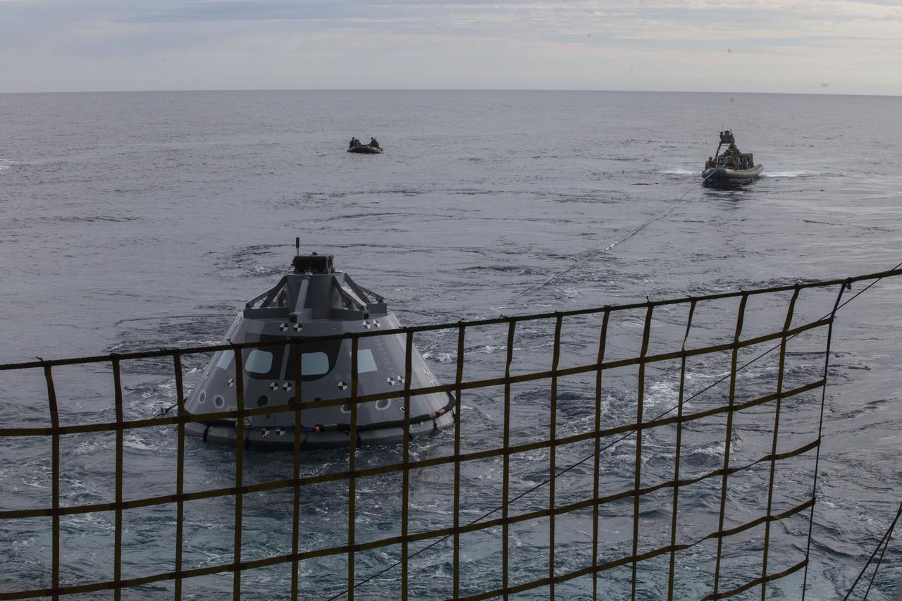 U.S. Navy divers and other personnel in a rigid hull inflatable boat are handling tether lines attached to a test version of the Orion crew module during Underway Recovery Test 5 in the Pacific Ocean off the coast of California. U.S. Navy divers in a smaller watercraft called a Zodiac boat are farther away. NASA's Ground Systems Development and Operations Program and the U.S. Navy are conducting a series of tests using the well deck of the USS San Diego, several watercraft and personnel to prepare for recovery of Orion on its return from deep space missions. The testing will allow the team to demonstrate and evaluate recovery processes, procedures, hardware and personnel in open waters. Orion is the exploration spacecraft designed to carry astronauts to destinations not yet explored by humans, including an asteroid and NASA's Journey to Mars. It will have emergency abort capability, sustain the crew during space travel and provide safe re-entry from deep space return velocities. Orion is scheduled to launch on NASA's Space Launch System in late 2018. For more information, visit http://www.nasa.gov/orion. 
