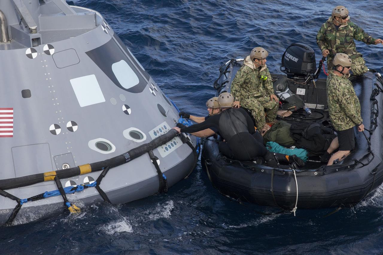 U.S. Navy divers and other personnel in a Zodiac boat secure a harness around a test version of the Orion crew module during Underway Recovery Test 5 in the Pacific Ocean off the coast of California. Tether lines will be attached to the test module to help guide it back to the well deck of the USS San Diego. NASA's Ground Systems Development and Operations Program and the U.S. Navy are practicing recovery techniques to prepare for recovery of Orion on its return from deep space missions. The testing will allow the team to demonstrate and evaluate recovery processes, procedures, hardware and personnel in open waters. Orion is the exploration spacecraft designed to carry astronauts to destinations not yet explored by humans, including an asteroid and NASA's Journey to Mars. It will have emergency abort capability, sustain the crew during space travel and provide safe re-entry from deep space return velocities. Orion is scheduled to launch on NASA's Space Launch System in late 2018. For more information, visit http://www.nasa.gov/orion.