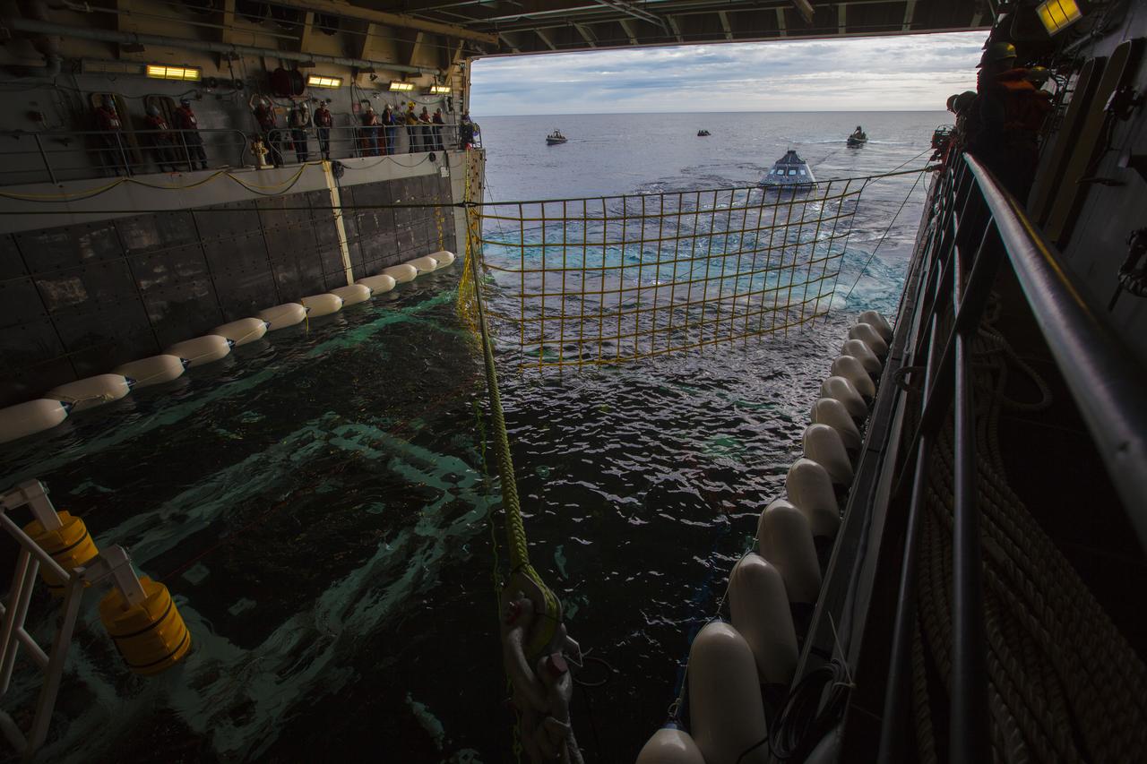 A test version of the Orion crew module is guided toward the flooded well deck of the USS San Diego during Underway Recovery Test 5. NASA's Ground Systems Development and Operations Program and the U.S. Navy are conducting a series of tests using the ship's well deck, the test module, various watercraft and equipment to prepare for recovery of Orion on its return from deep space missions. The test will allow the team to demonstrate and evaluate recovery processes, procedures, hardware and personnel in open waters. Orion is the exploration spacecraft designed to carry astronauts to destinations not yet explored by humans, including an asteroid and NASA's Journey to Mars. It will have emergency abort capability, sustain the crew during space travel and provide safe re-entry from deep space return velocities. Orion is scheduled to launch on NASA's Space Launch System in late 2018. For more information, visit http://www.nasa.gov/orion. 