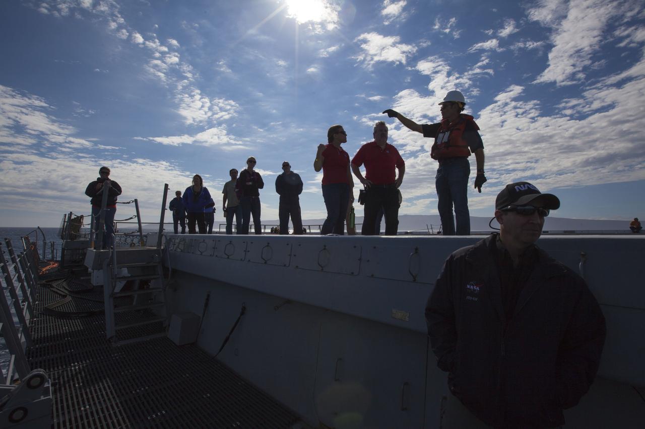 A brilliant sun and blue sky are the backdrop for Underway Recovery Test 5 in the Pacific Ocean off the coast of California. Recovery team members are on the flight deck of the USS San Diego. NASA's Ground Systems Development and Operations Program and the U.S. Navy are conducting a series of tests using the ship's well deck, a test version of the Orion crew module, various watercraft and equipment to prepare for recovery of Orion on its return from deep space missions. The test will allow the team to demonstrate and evaluate recovery processes, procedures, hardware and personnel in open waters. Orion is the exploration spacecraft designed to carry astronauts to destinations not yet explored by humans, including an asteroid and NASA's Journey to Mars. It will have emergency abort capability, sustain the crew during space travel and provide safe re-entry from deep space return velocities. Orion is scheduled to launch on NASA's Space Launch System in late 2018. For more information, visit http://www.nasa.gov/orion.