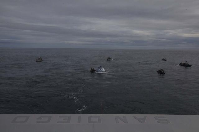U.S. Navy divers and other personnel in several rigid hull inflatable and Zodiac boats have surrounded a test version of the Orion crew module during Underway Recovery Test 5 in the Pacific Ocean off the coast of California. An orange winch line has been attached to the test module to pull it into the well deck of the USS San Diego. NASA's Ground Systems Development and Operations Program and the U.S. Navy are conducting a series of tests using the Navy ship, various watercraft and equipment to practice for recovery of Orion on its return from deep space missions. The testing allows the team to demonstrate and evaluate recovery processes, procedures, hardware and personnel in open waters. Orion is the exploration spacecraft designed to carry astronauts to destinations not yet explored by humans, including an asteroid and NASA's Journey to Mars. It will have emergency abort capability, sustain the crew during space travel and provide safe re-entry from deep space return velocities. Orion is scheduled to launch on NASA's Space Launch System in late 2018. For more information, visit http://www.nasa.gov/orion.