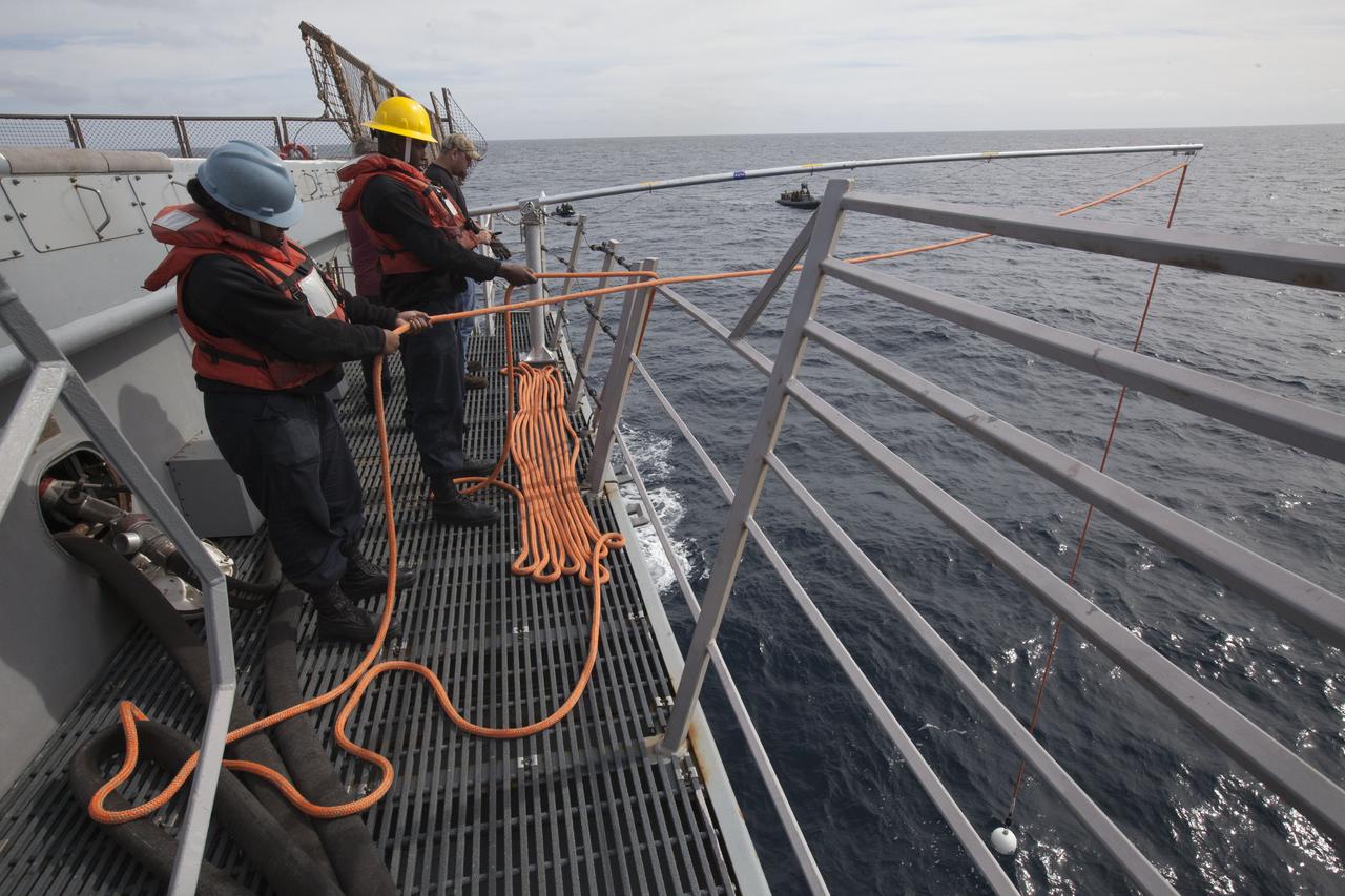 U.S. Navy personnel check tether lines and a winch line on the deck of the USS San Diego in the Pacific Ocean off the coast of California. NASA's Ground Systems Development and Operations Program and the U.S. Navy are conducting a series of tests, called Underway Recovery Test 5, using the ship's well deck and a test version of the Orion crew module to prepare for recovery of Orion on its return from deep space missions. The testing will allow the team to demonstrate and evaluate recovery processes, procedures, hardware and personnel in open waters. Orion is the exploration spacecraft designed to carry astronauts to destinations not yet explored by humans, including an asteroid and NASA's Journey to Mars. It will have emergency abort capability, sustain the crew during space travel and provide safe re-entry from deep space return velocities. Orion is scheduled to launch on NASA's Space Launch System in late 2018. For more information, visit http://www.nasa.gov/orion. 