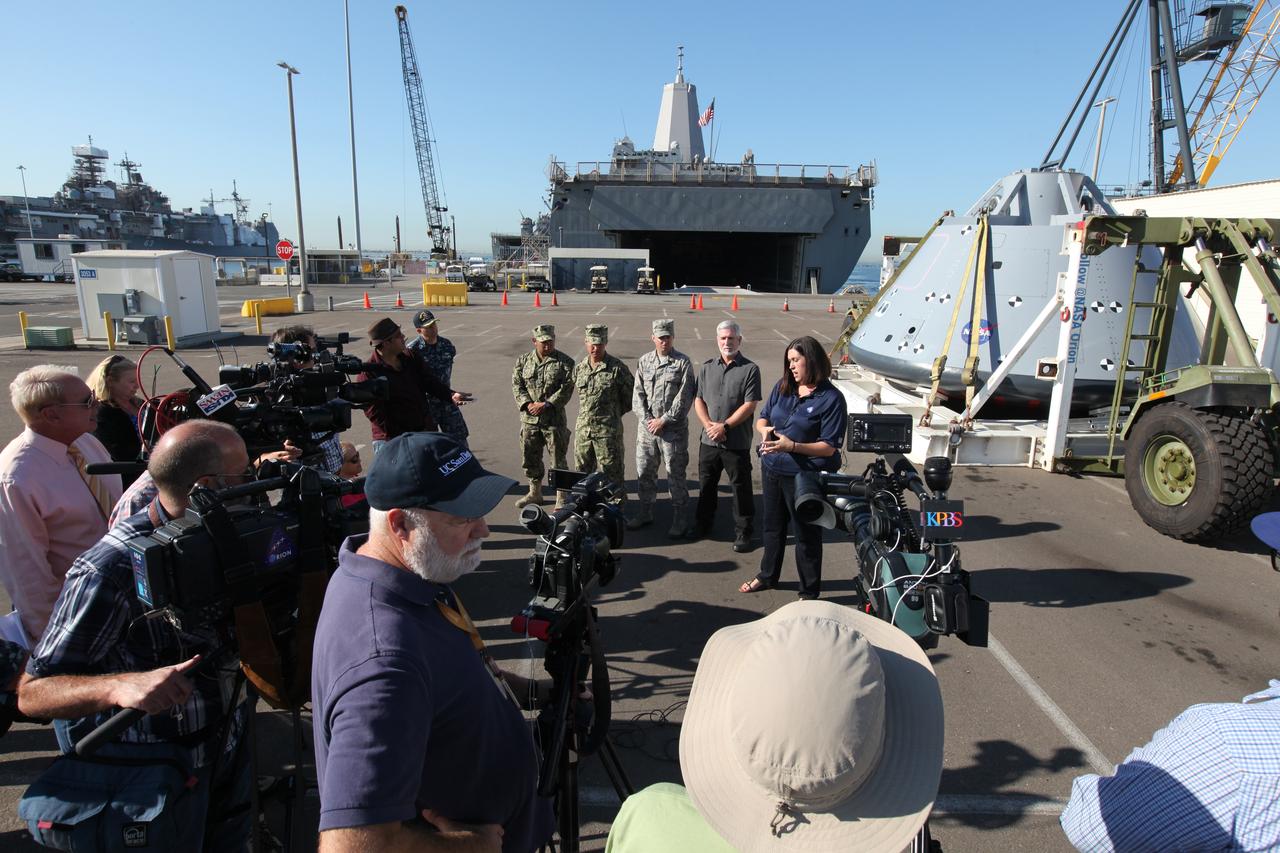 Melissa Jones, far right, Landing and Recovery director with the Ground Systems Development and Operations Program (GSDO), speaks to members of the media about Orion Underway Recovery Test 5. The USS San Diego is docked at Naval Base San Diego in California and the test version of the Orion crew module, secured on its handling fixture, was offloaded from the well deck of the ship. NASA's GSDO Program and the U.S. Navy completed a series of tests using the ship's well deck, the test module, various watercraft and equipment to prepare for recovery of Orion on its return from deep space missions. The testing allowed the team to demonstrate and evaluate recovery processes, procedures, hardware and personnel in open waters. Orion is the exploration spacecraft designed to carry astronauts to destinations not yet explored by humans, including an asteroid and NASA's Journey to Mars. It will have emergency abort capability, sustain the crew during space travel and provide safe re-entry from deep space return velocities. Orion is scheduled to launch on NASA's Space Launch System in late 2018. For more information, visit http://www.nasa.gov/orion.