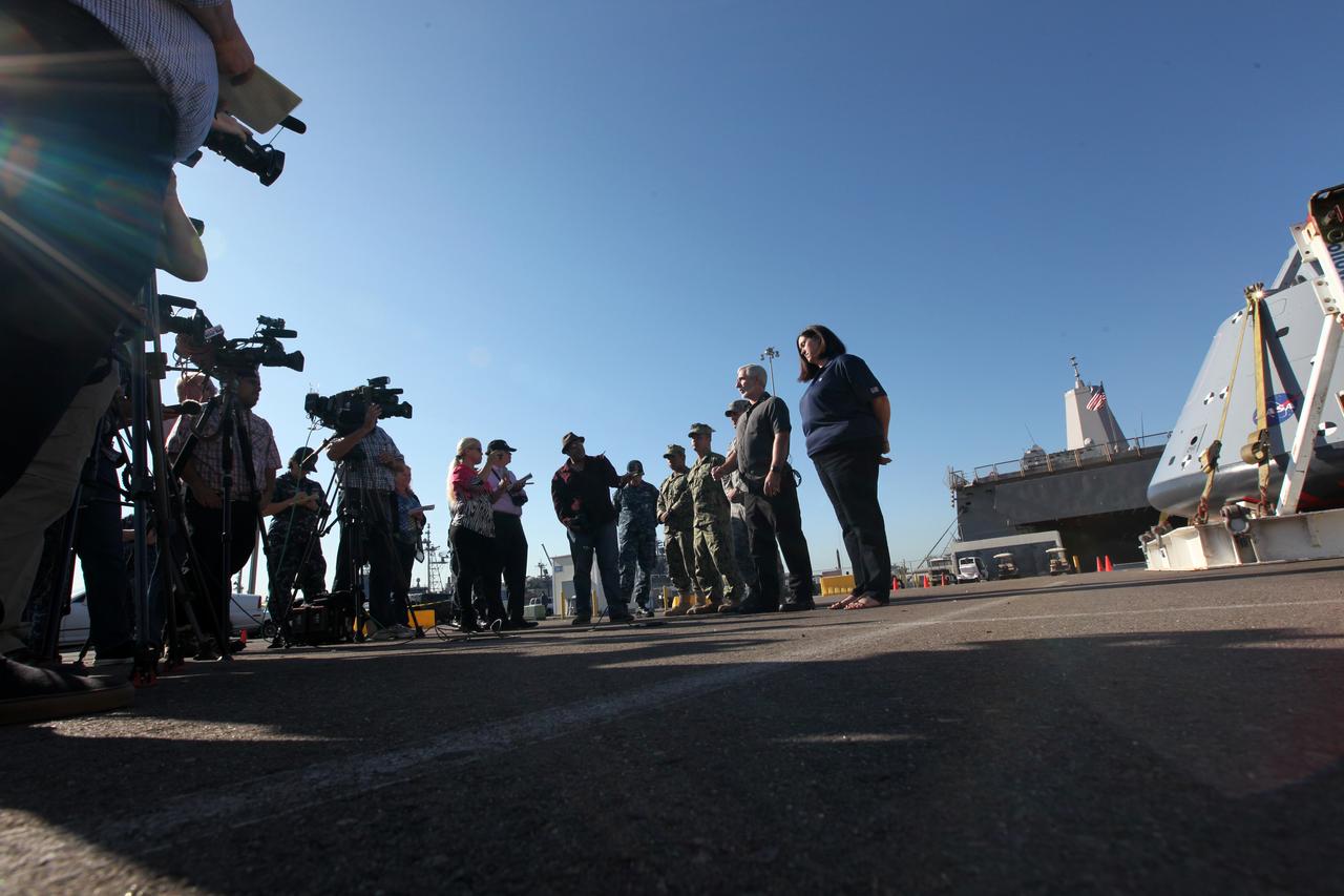 Melissa Jones, far right, Landing and Recovery director with the Ground Systems Development and Operations Program (GSDO), and other members of the recovery team speak to members of the media about Orion Underway Recovery Test 5. The USS San Diego is docked at Naval Base San Diego in California and the test version of the Orion crew module, secured on its handling fixture, was offloaded from the well deck of the ship. NASA's GSDO Program and the U.S. Navy completed a series of tests using the ship's well deck, the test module, various watercraft and equipment to prepare for recovery of Orion on its return from deep space missions. The testing allowed the team to demonstrate and evaluate recovery processes, procedures, hardware and personnel in open waters. Orion is the exploration spacecraft designed to carry astronauts to destinations not yet explored by humans, including an asteroid and NASA's Journey to Mars. It will have emergency abort capability, sustain the crew during space travel and provide safe re-entry from deep space return velocities. Orion is scheduled to launch on NASA's Space Launch System in late 2018. For more information, visit http://www.nasa.gov/orion. 