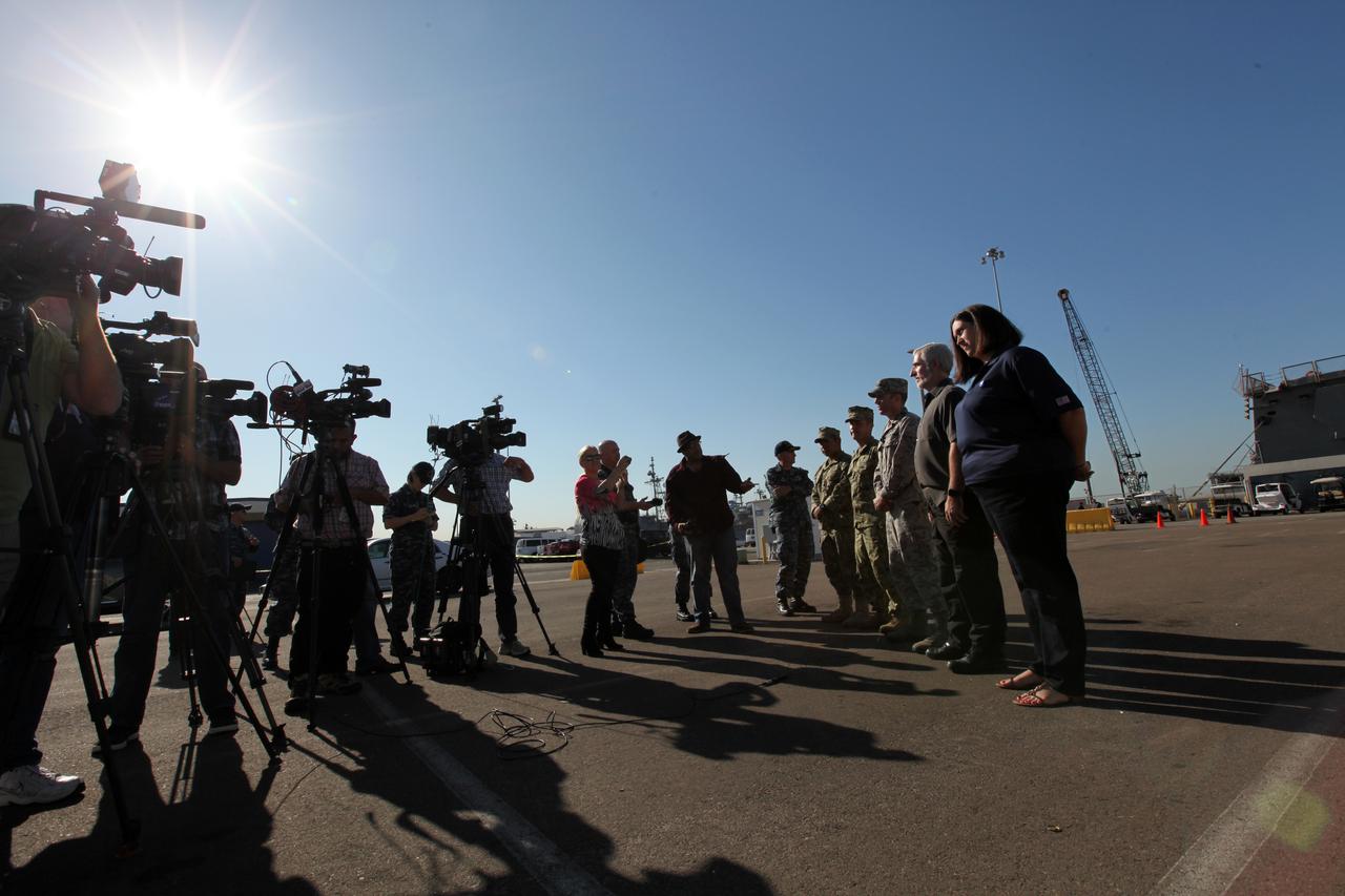 Melissa Jones, far right, Landing and Recovery director with the Ground Systems Development and Operations Program (GSDO), and other members of the recovery team speak to members of the media about Orion Underway Recovery Test 5. The USS San Diego is docked at Naval Base San Diego in California and the test version of the Orion crew module, secured on its handling fixture, was offloaded from the well deck of the ship. NASA's GSDO Program and the U.S. Navy completed a series of tests using the ship's well deck, the test module, various watercraft and equipment to prepare for recovery of Orion on its return from deep space missions. The testing allowed the team to demonstrate and evaluate recovery processes, procedures, hardware and personnel in open waters. Orion is the exploration spacecraft designed to carry astronauts to destinations not yet explored by humans, including an asteroid and NASA's Journey to Mars. It will have emergency abort capability, sustain the crew during space travel and provide safe re-entry from deep space return velocities. Orion is scheduled to launch on NASA's Space Launch System in late 2018. For more information, visit http://www.nasa.gov/orion.