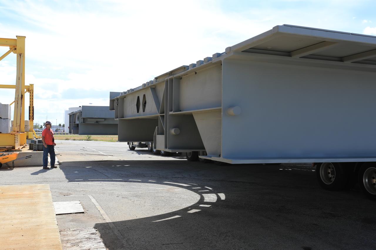 A heavy load transport truck from Tillett Heavy Hauling in Titusville, Florida, arrives at the Vehicle Assembly Building (VAB) at NASA’s Kennedy Space Center in Florida, carrying the second half of the B-level work platforms, B north, for the agency’s Space Launch System (SLS) rocket. The platform will be offloaded in the VAB staging area in the west parking lot. The Ground Systems Development and Operations Program is overseeing upgrades and modifications to VAB High Bay 3 to support processing of the SLS and Orion spacecraft. A total of 10 levels of new platforms, 20 platform halves altogether, will surround the SLS rocket and Orion spacecraft and provide access for testing and processing.