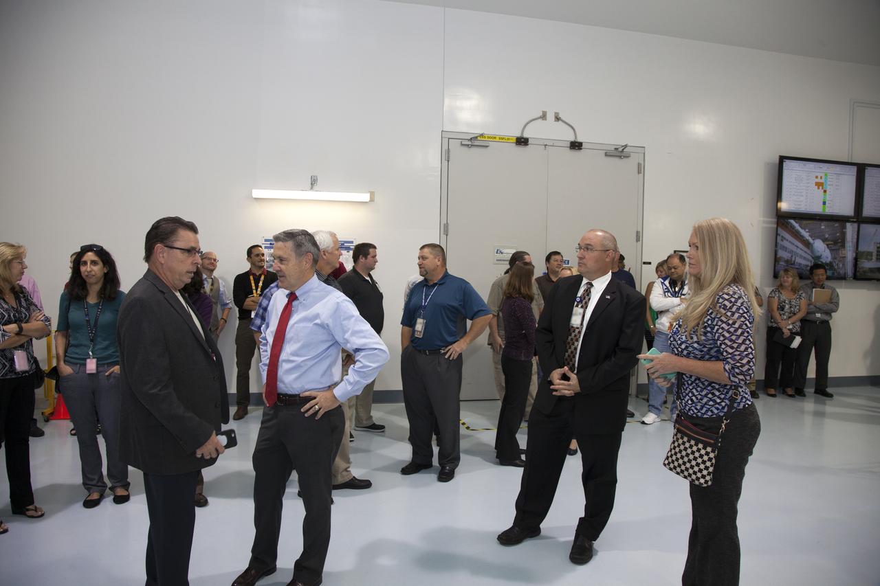 Kennedy Space Center Director Bob Cabana, center, talks with Bill Dowdell, Kennedy's International Space Station technical director, during a ribbon cutting ceremony in the high bay of the Space Station Processing Facility at the Florida spaceport. The event celebrated completion of facility modifications to improve processing and free up zones tailored to a variety of needs supporting a robust assortment of space-bound hardware including NASA programs and commercial space companies.