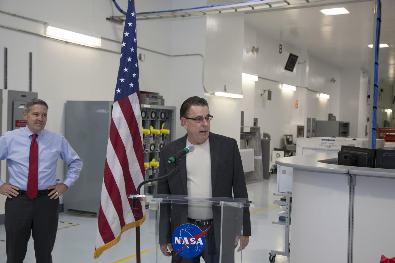 Bill Dowdell, International Space Station technical director, speaks to guests during a ribbon cutting ceremony in the high bay of the Space Station Processing Facility at NASA's Kennedy Space Center in Florida spaceport. Joining him is Kennedy's director, Bob Cabana. The event celebrated completion of facility modifications to improve processing and free up zones tailored to a variety of needs supporting a robust assortment of space-bound hardware including NASA programs and commercial space companies.