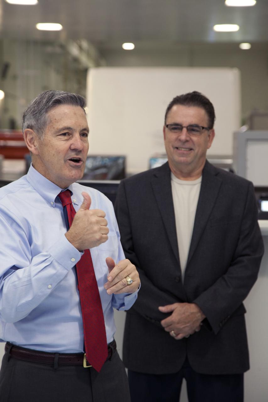 Kennedy Space Center Director Bob Cabana, left, speaks to guests during a ribbon cutting ceremony in the high bay of the Space Station Processing Facility at the Florida Space port. With him is Bill Dowdell, International Space Station technical director. The event celebrated completion of facility modifications to improve processing and free up zones tailored to a variety of needs supporting a robust assortment of space-bound hardware including NASA programs and commercial space companies.