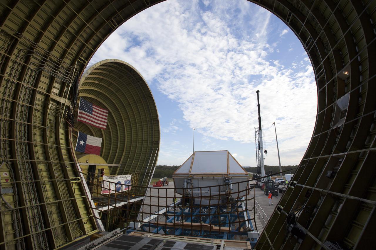 After arriving at the Shuttle Landing Facility operated by Space Florida at NASA's Kennedy Space Center in Florida, the agency's Super Guppy aircraft has been opened and the container holding the Orion crew module structural test article (STA) is being offloaded. The test article will be transported to the Neil Armstrong Operations and Checkout Building high bay for further testing. The Orion spacecraft will launch atop NASA’s Space Launch System rocket on EM-1, its first deep space mission, in late 2018.