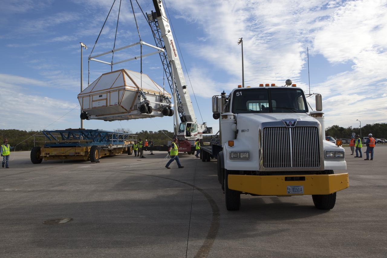 After arriving at the Shuttle Landing Facility operated by Space Florida at NASA's Kennedy Space Center in Florida, the agency's Super Guppy aircraft was opened and the container holding the Orion crew module structural test article (STA) was offloaded. A crane has lifted the container for placement on a transporter. The test article will be moved to the Neil Armstrong Operations and Checkout Building high bay for further testing. The Orion spacecraft will launch atop NASA’s Space Launch System rocket on EM-1, its first deep space mission, in late 2018.