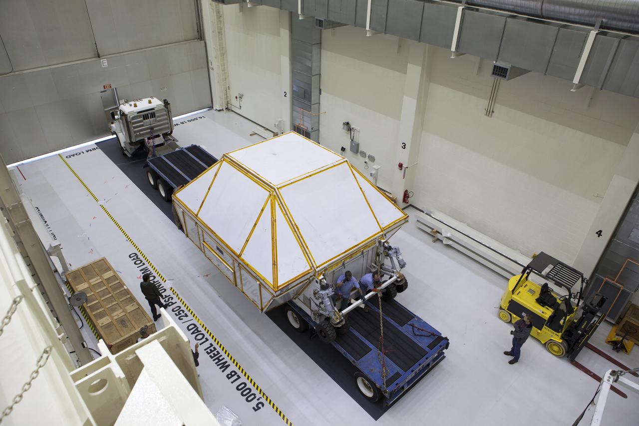 A transporter carrying the Orion crew module structural test article (STA) in its container arrives inside the low bay of the Neil Armstrong Operations and Checkout Building at NASA's Kennedy Space Center in Florida. The STA arrived aboard NASA's Super Guppy aircraft at the Shuttle Landing Facility operated by Space Florida. The test article will be moved inside the facility's high bay for further testing. The Orion spacecraft will launch atop NASA’s Space Launch System rocket on EM-1, its first deep space mission, in late 2018.
